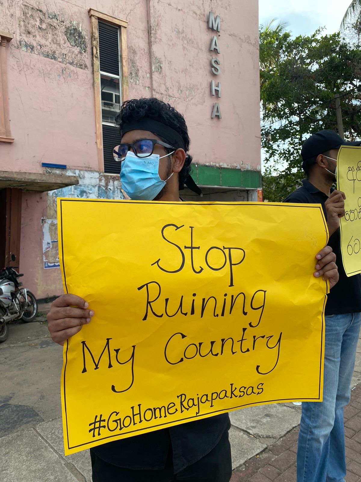 A protester in Sri Lanka's capital Colombo hold up a sign demanding the President 'stop ruining my country'. 
