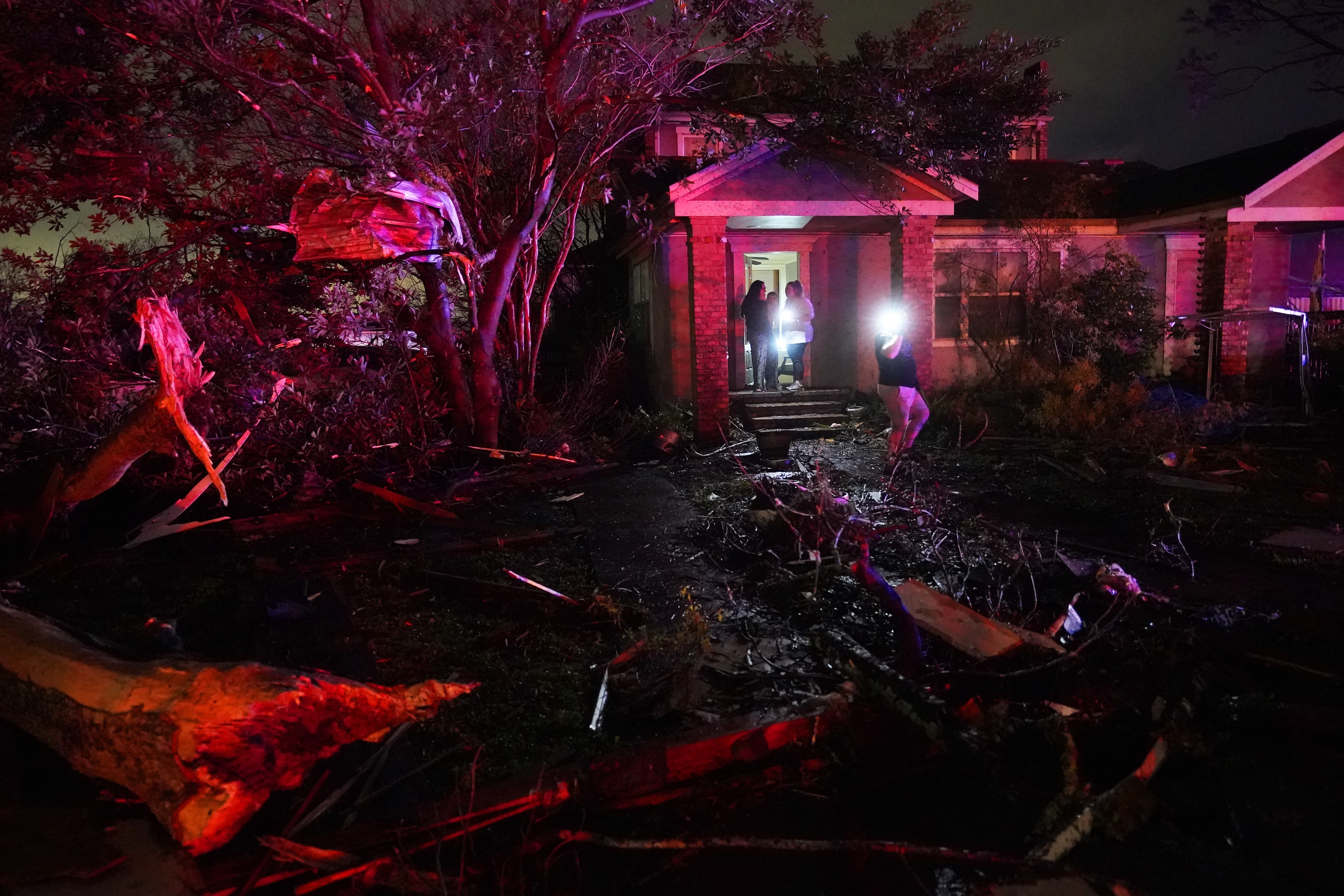 People survey damage in Arabi, Louisiana after power lines were ripped down and debris scattered amid the tornado. 