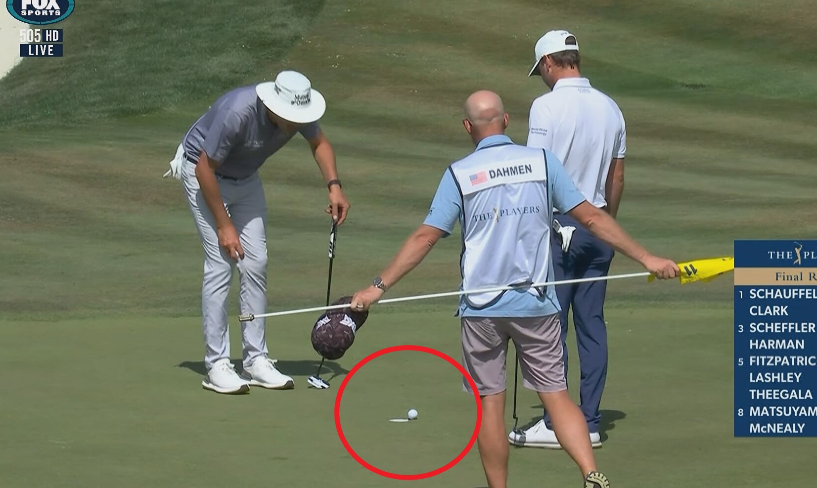 Austin Eckroat and Joel Dahmen watch Eckroat's ball as it teeters on the edge of the cup.