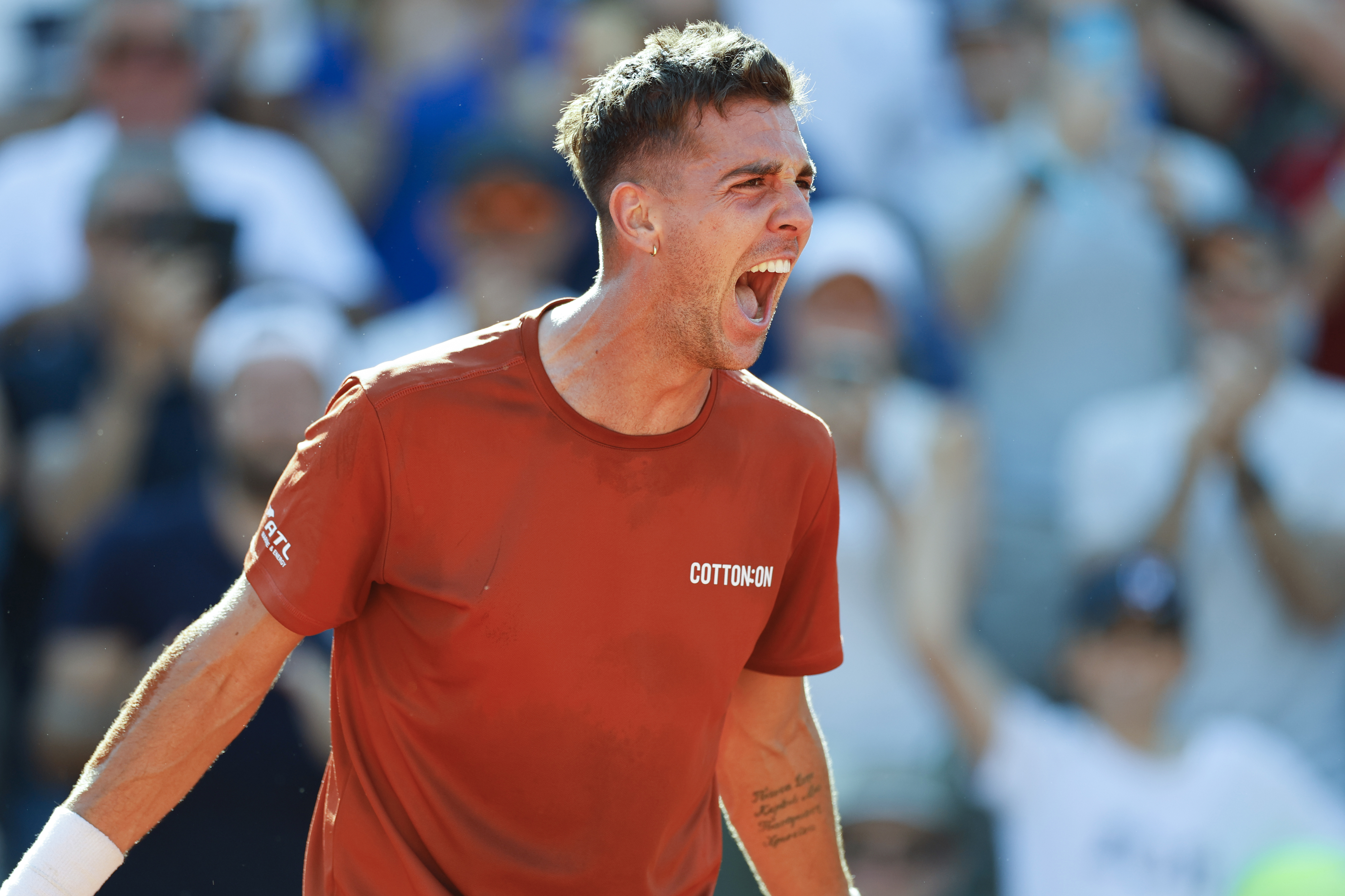 Australia's Thanasi Kokkinakis celebrates after winning his second round match of the French Open tennis tournament against Switzerland's Stan Wawrinka.