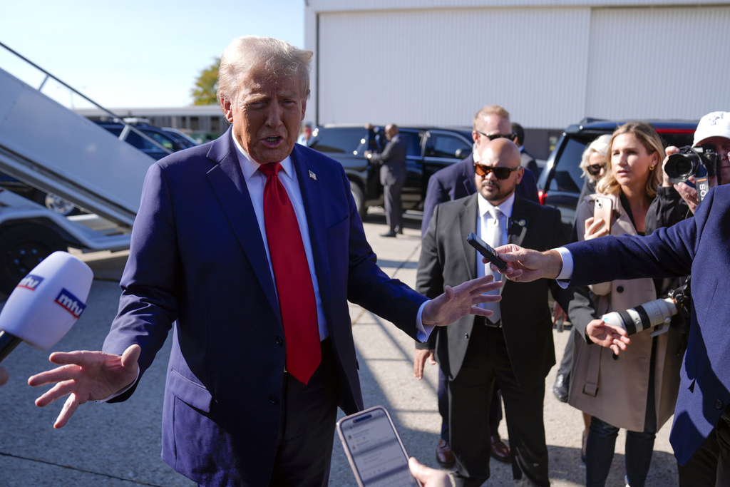 El expresidente Donald Trump, candidato presidencial republicano, habla con los periodistas cuando llega al Aeropuerto Metropolitano del Condado de Wayne de Detroit, el viernes 18 de octubre de 2024, en Detroit. (Foto AP/Evan Vucci)