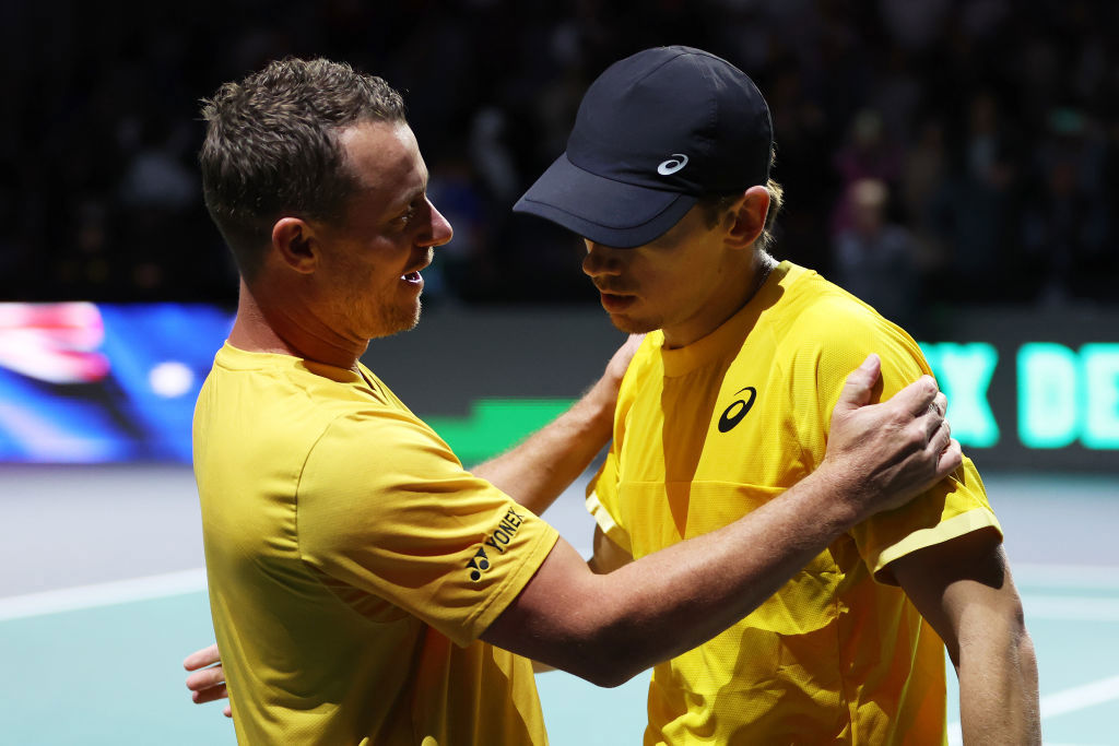 Lleyton Hewitt embraces Alex De Minaur of Australia.