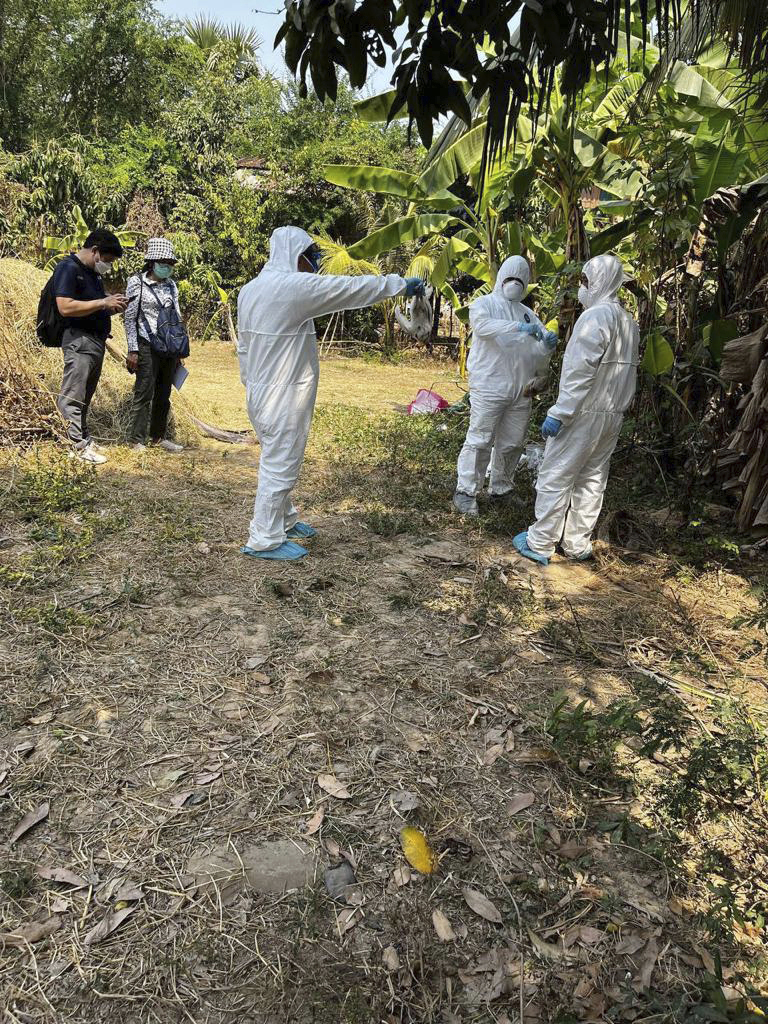 Experts spray disinfectant at a village in Prey Veng eastern province Cambodia, Friday, Feb. 24, 2023, after the father of an 11-year old girl who died this week tested positive for bird flu. 