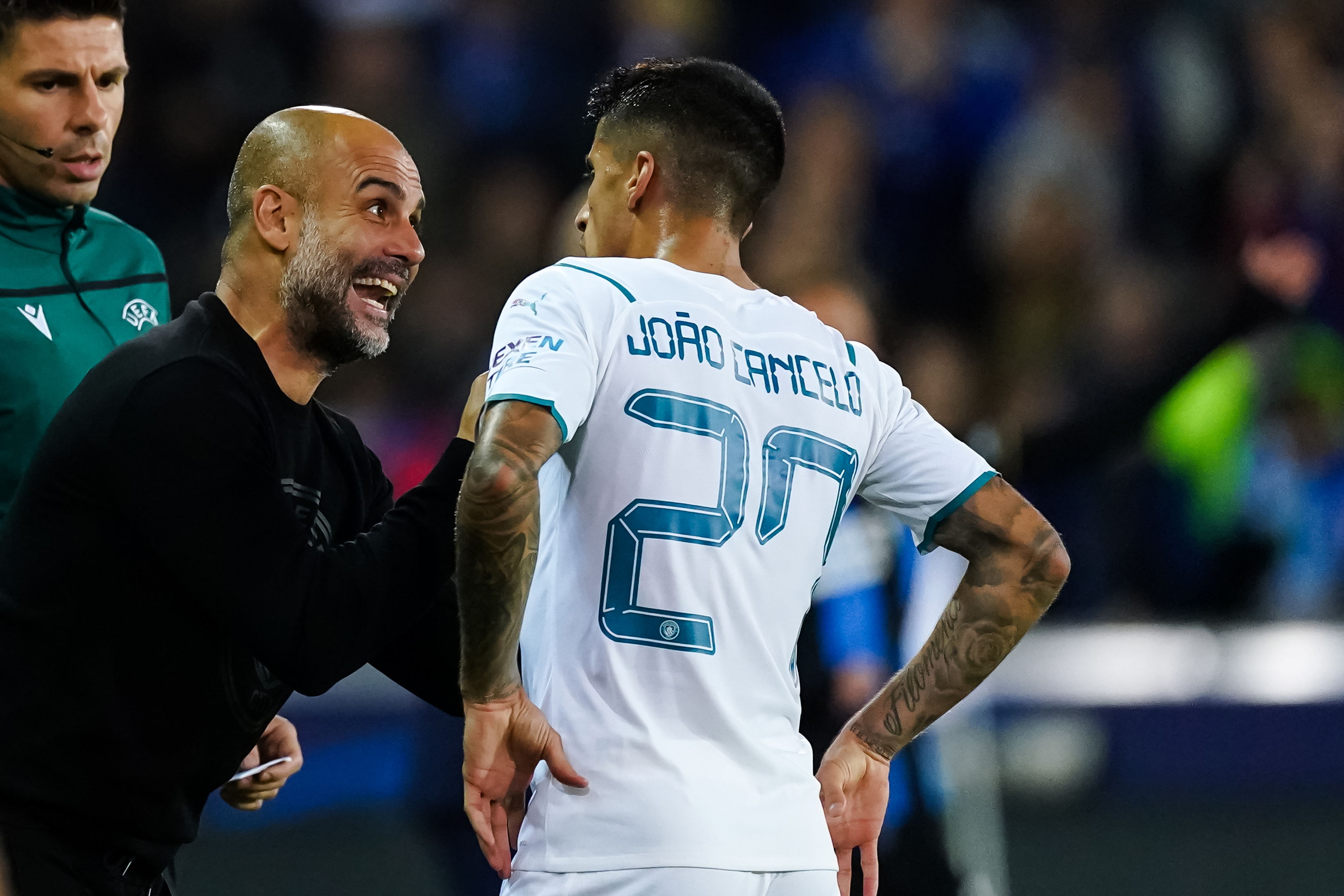 Pep Guardiola of Manchester City in discussion with Joao Cancelo.