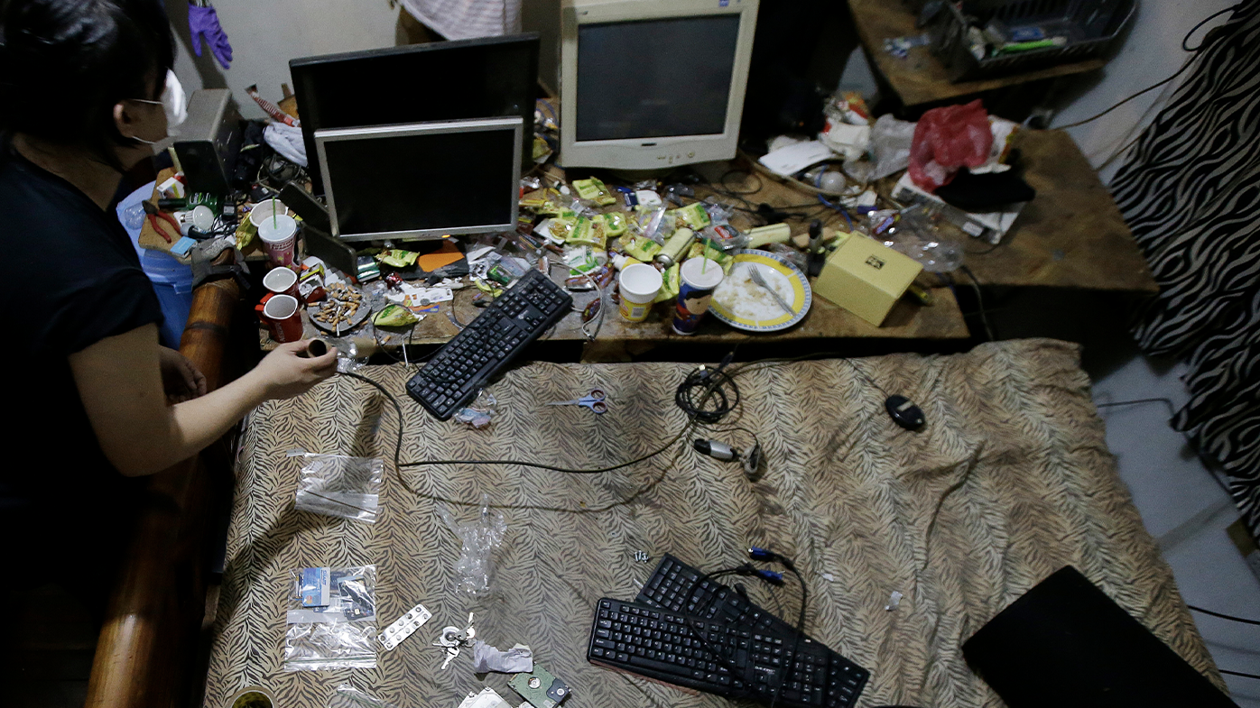 In this April 20, 2017, file photo, members of the National Bureau of Investigation and FBI gather evidence at the home of suspected child webcam cybersex operator, David Timothy Deakin, from Peoria, Ill., during a raid in Mabalacat, Philippines. 