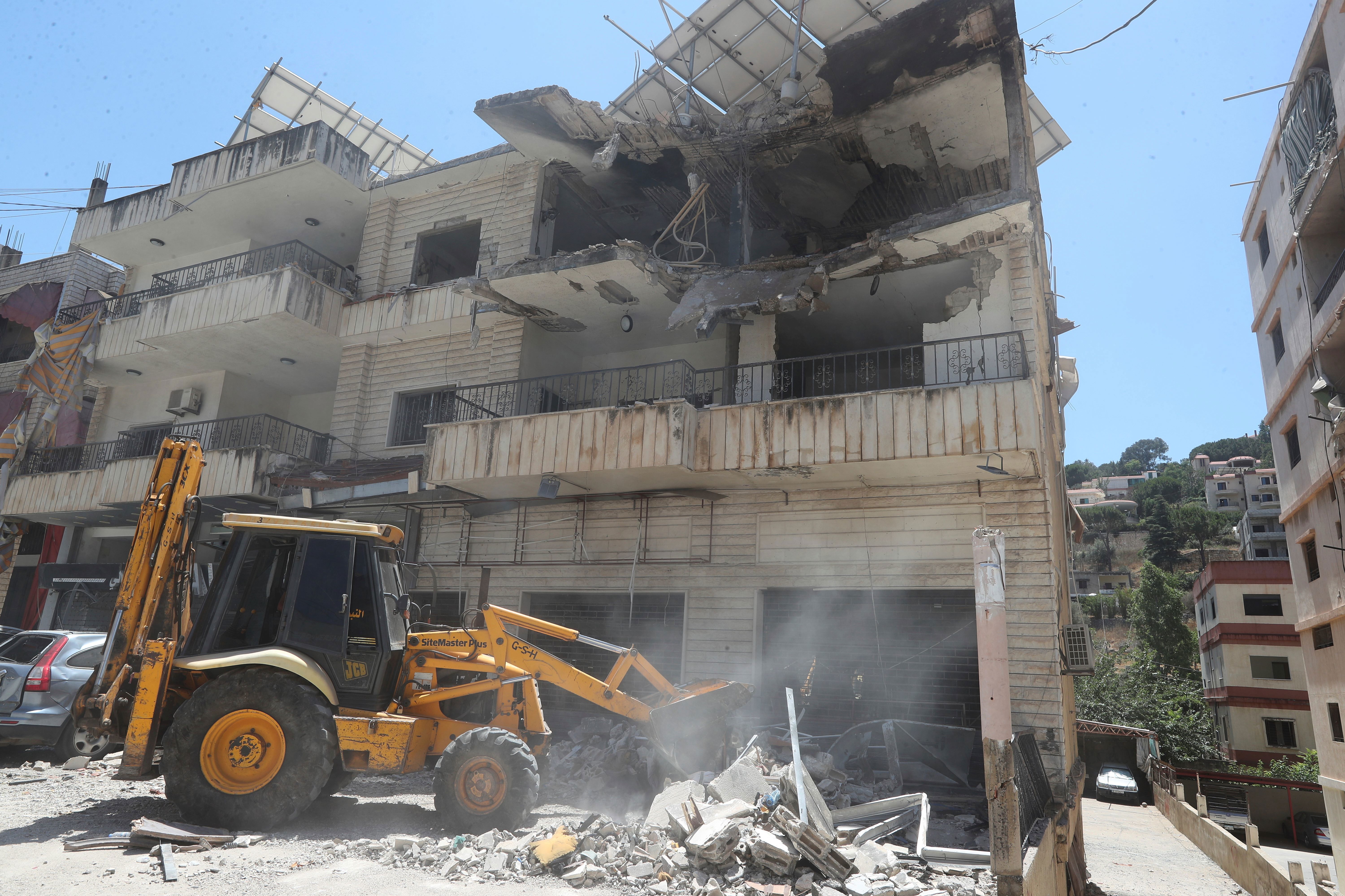 A bulldozer clears rubble near a destroyed building that was hit in an Israeli airstrike in Nabatieh town, south Lebanon, Friday, June 27, 2025. (AP Photo/Mohammed Zaatari)