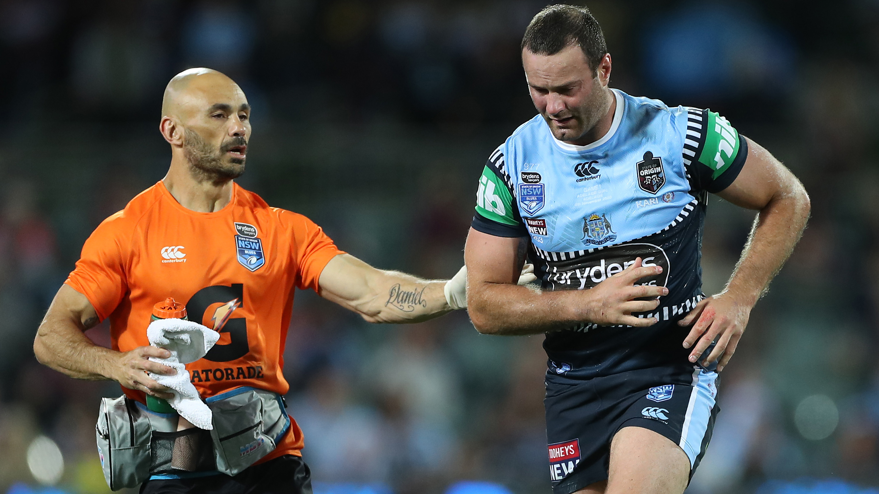 An unsteady Boyd Cordner is attended to by the NSW trainer.