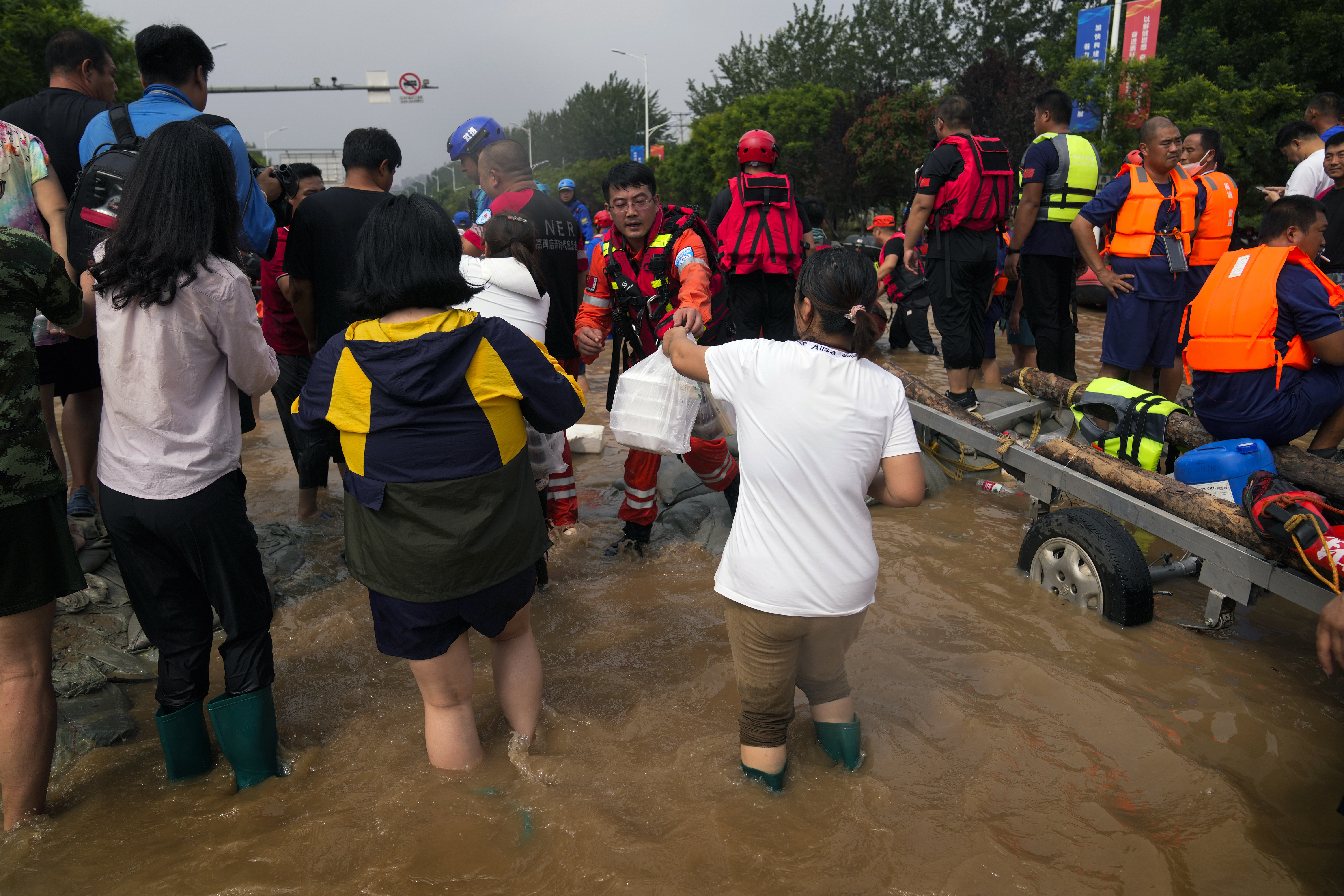 Volunteers distribute foods to rescuers before they send them to flood trapped residents, in Zhuozhou in northern China's Hebei province, south of Beijing, Wednesday, Aug. 2, 2023. China's capital has recorded its heaviest rainfall in at least 140 years over the past few days. Among the hardest hit areas is Zhuozhou, a small city that borders Beijing's southwest. (AP Photo/Andy Wong)