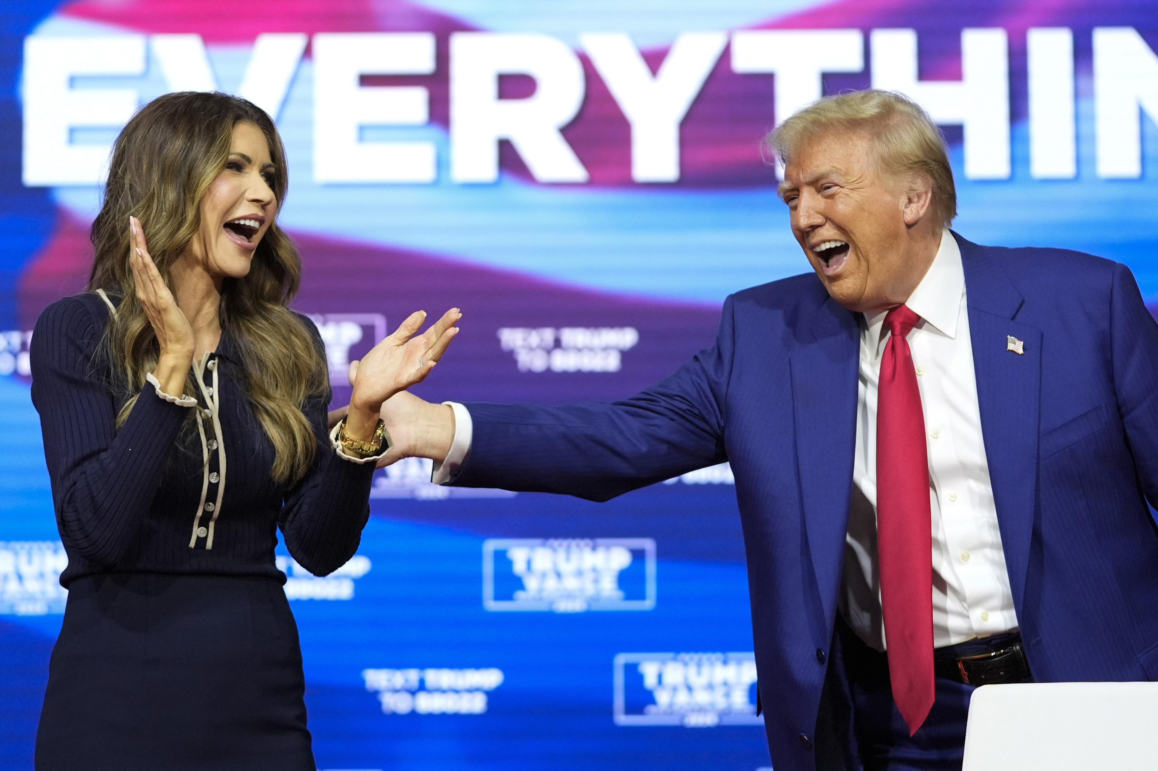 El expresidente candidato presidencial republicano Donald Trump reacciona con la gobernadora de Dakota del Sur, Kristi Noem, después de bailar la canción YMCA en un ayuntamiento de campaña en el Greater Philadelphia Expo Center & Fairgrounds, el lunes 14 de octubre de 2024, en Oaks, Pensilvania.