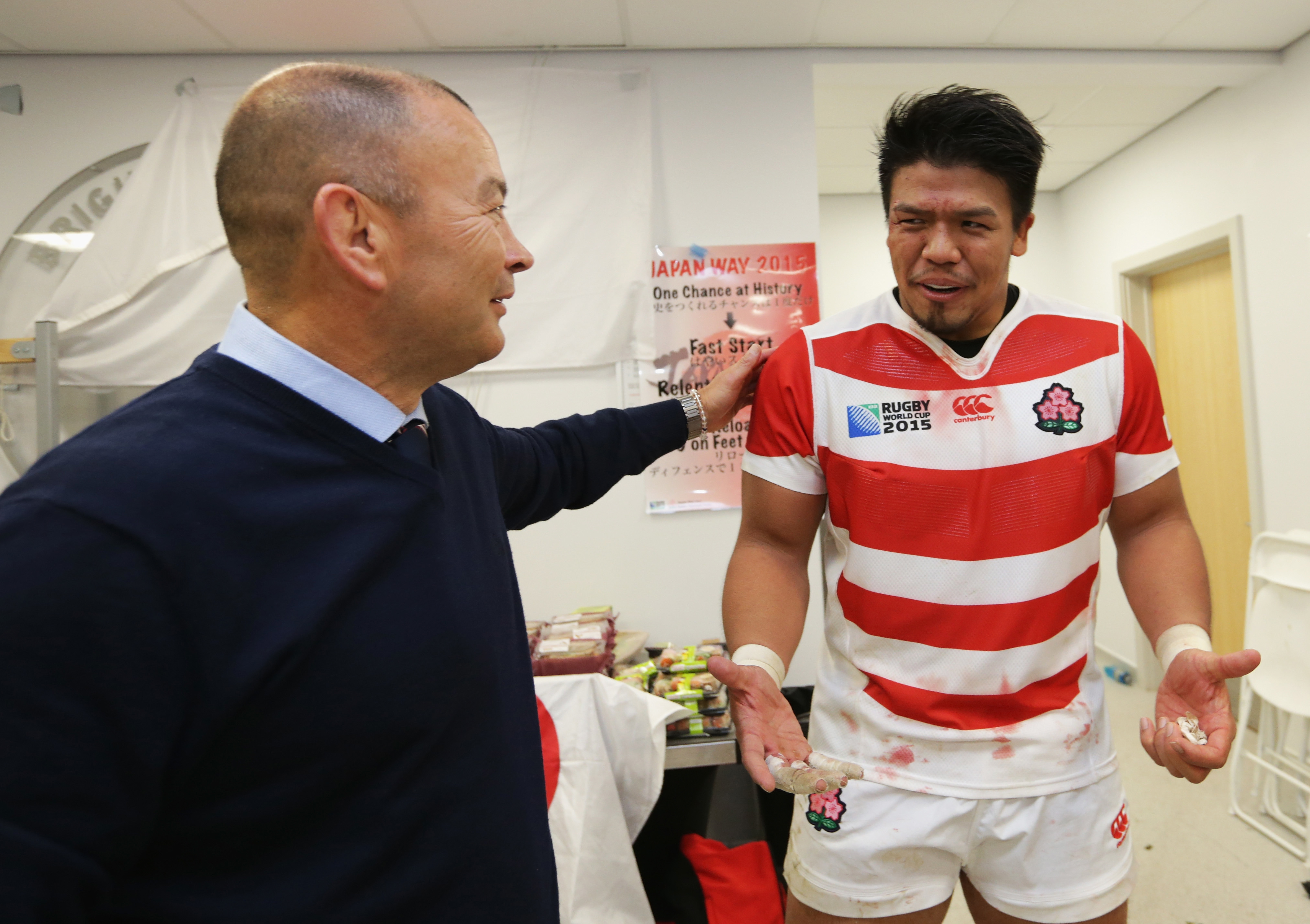 Japan coach Eddie Jones congratulates Takeshi Kizu following their surprise victory over South Africa at the 2015 Rugby World Cup.