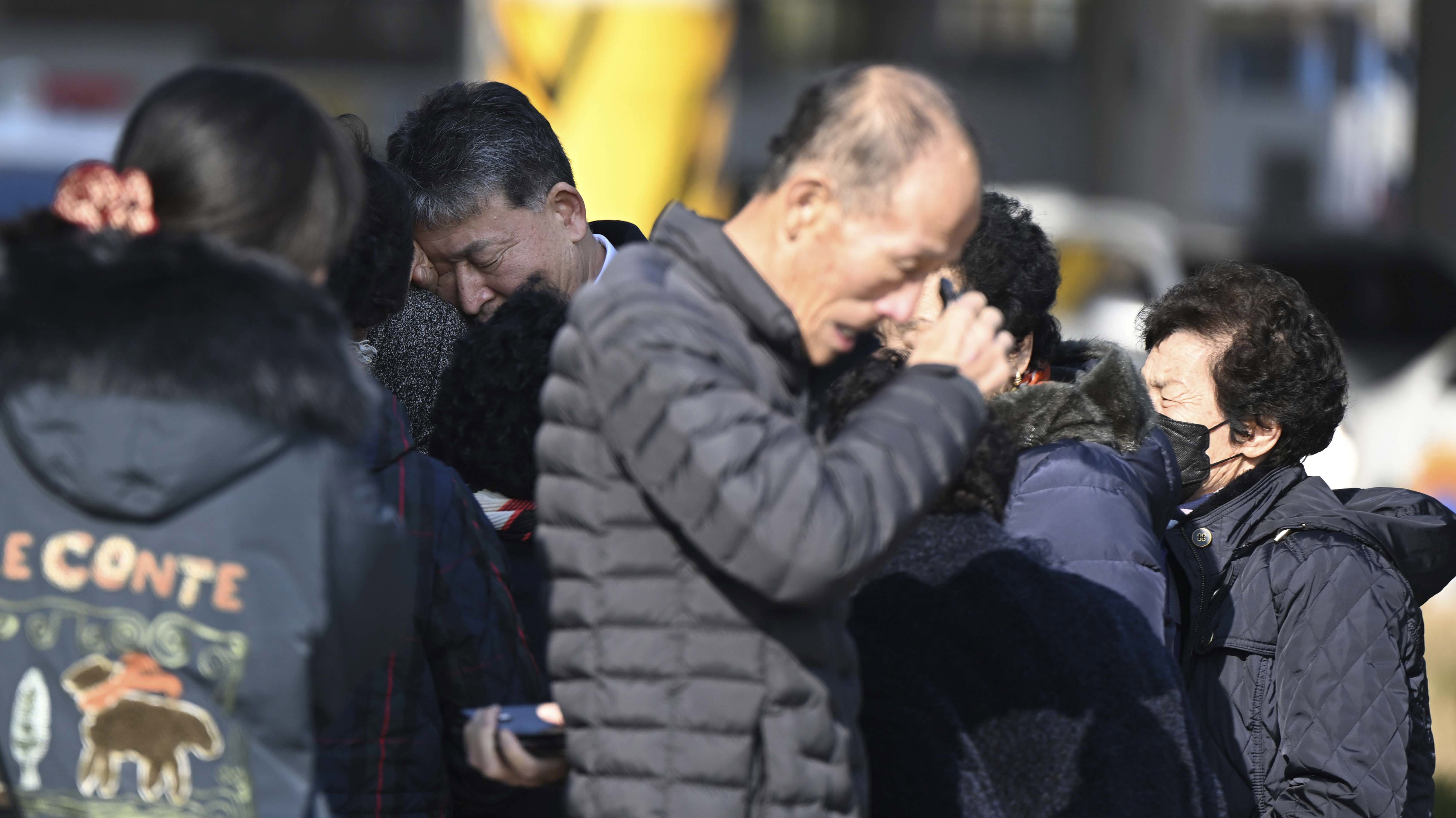 Family members of the passengers on a plane which burst into flames, weep at the Muan International Airport in Muan, South Korea.