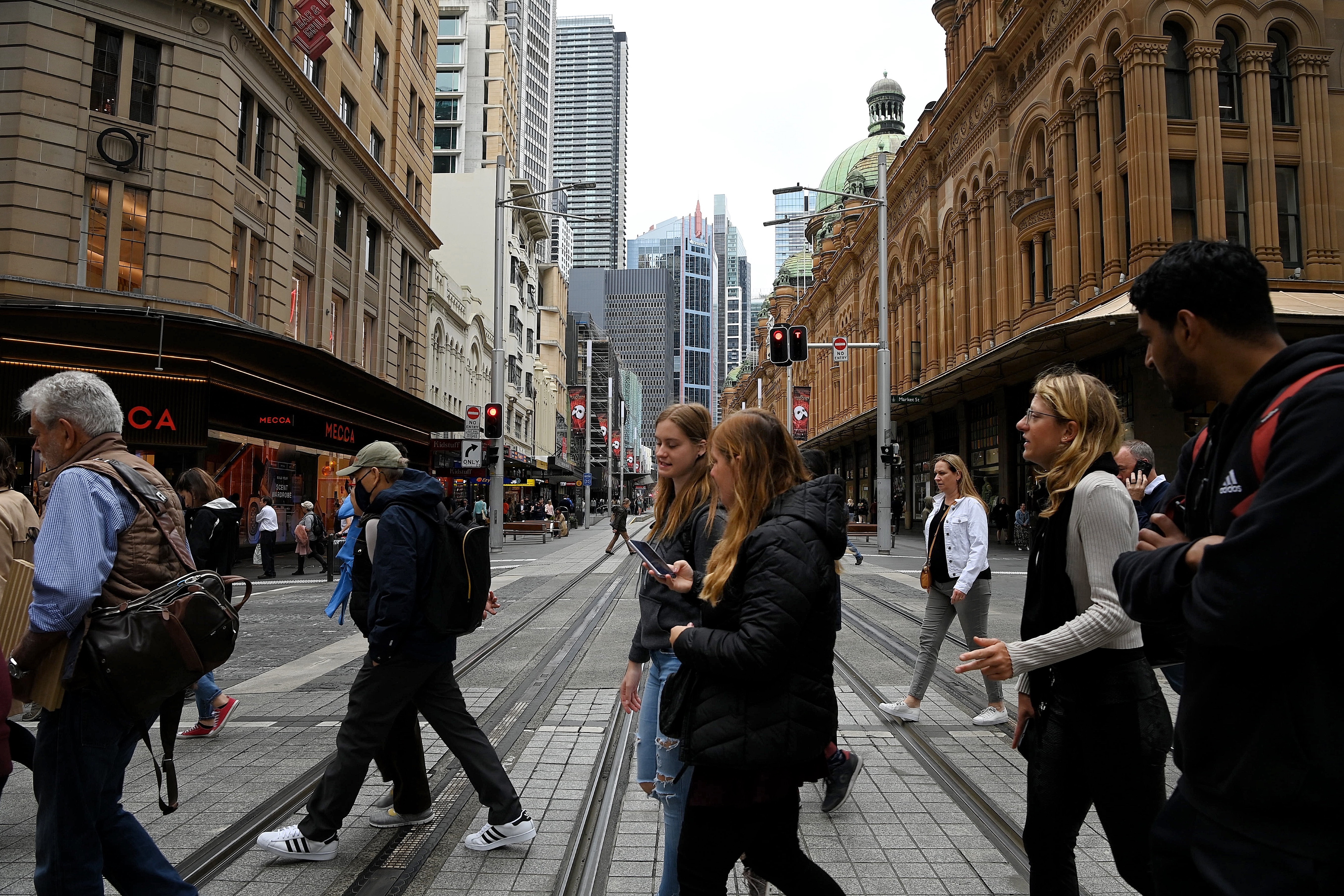People cross over Pitt street as they walk along Market street in the CBD of Sydney.
