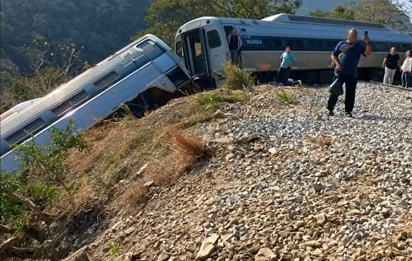 Passengers were seen on the railway tracks after escaping from the crashed train.