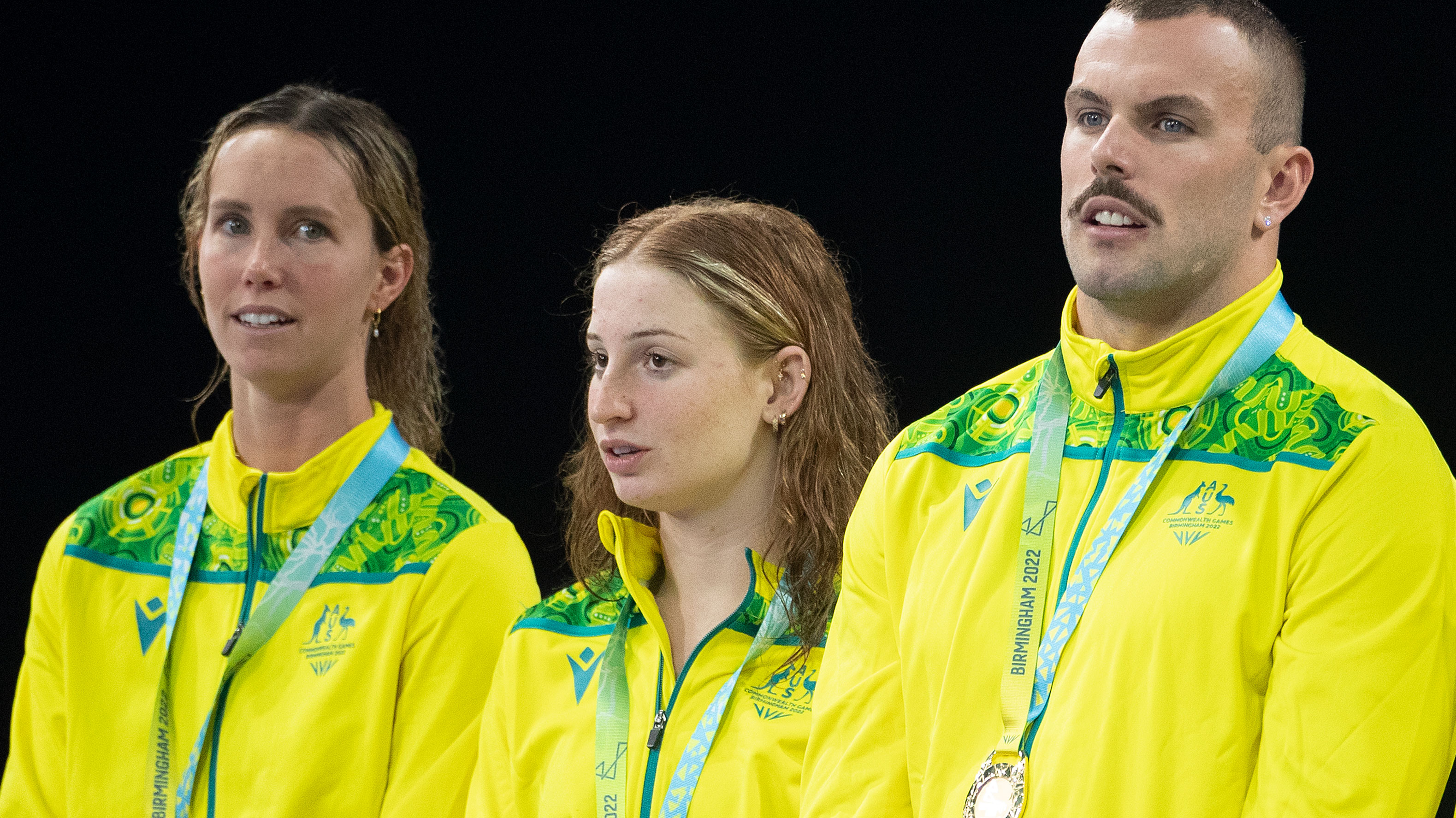 Emma McKeon (left) and Kyle Chalmers (right), are separated on the podium by Mollie O'Callaghan after winning the mixed 4x100m freestyle relay.