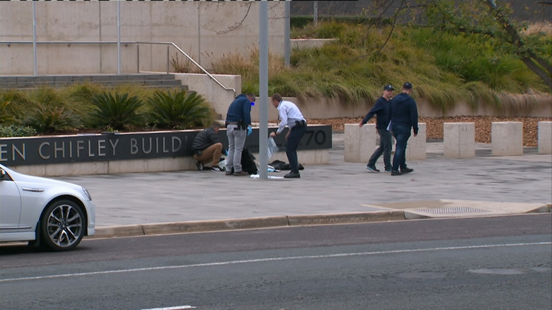 Officers and officials gather at the scene of the incident outside the ASIO building.