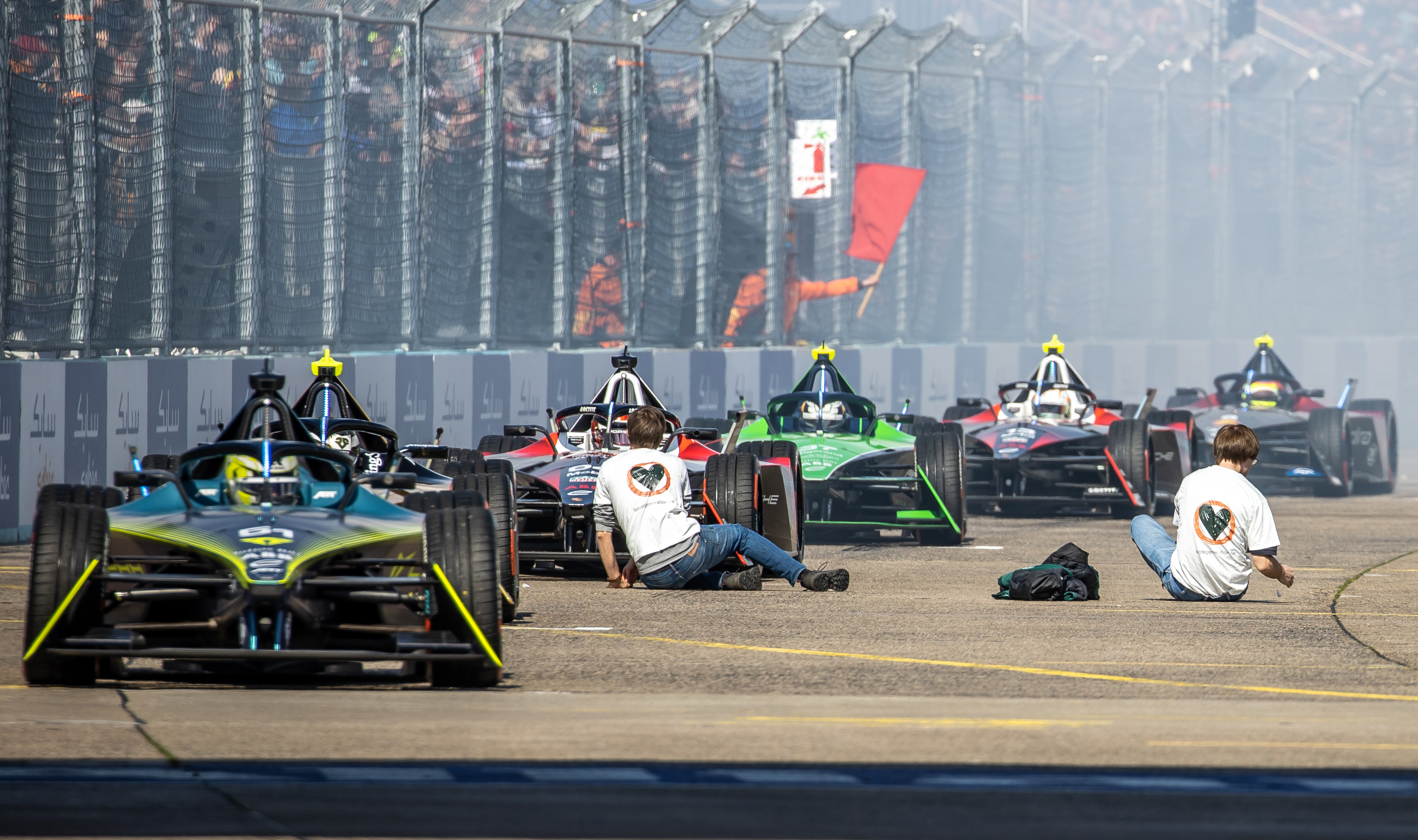 Last generation climate activists sit on the track in front of the Formula E race cars ready to start. Photo: Andreas Gora/dpa (Photo by Andreas Gora/picture alliance via Getty Images)