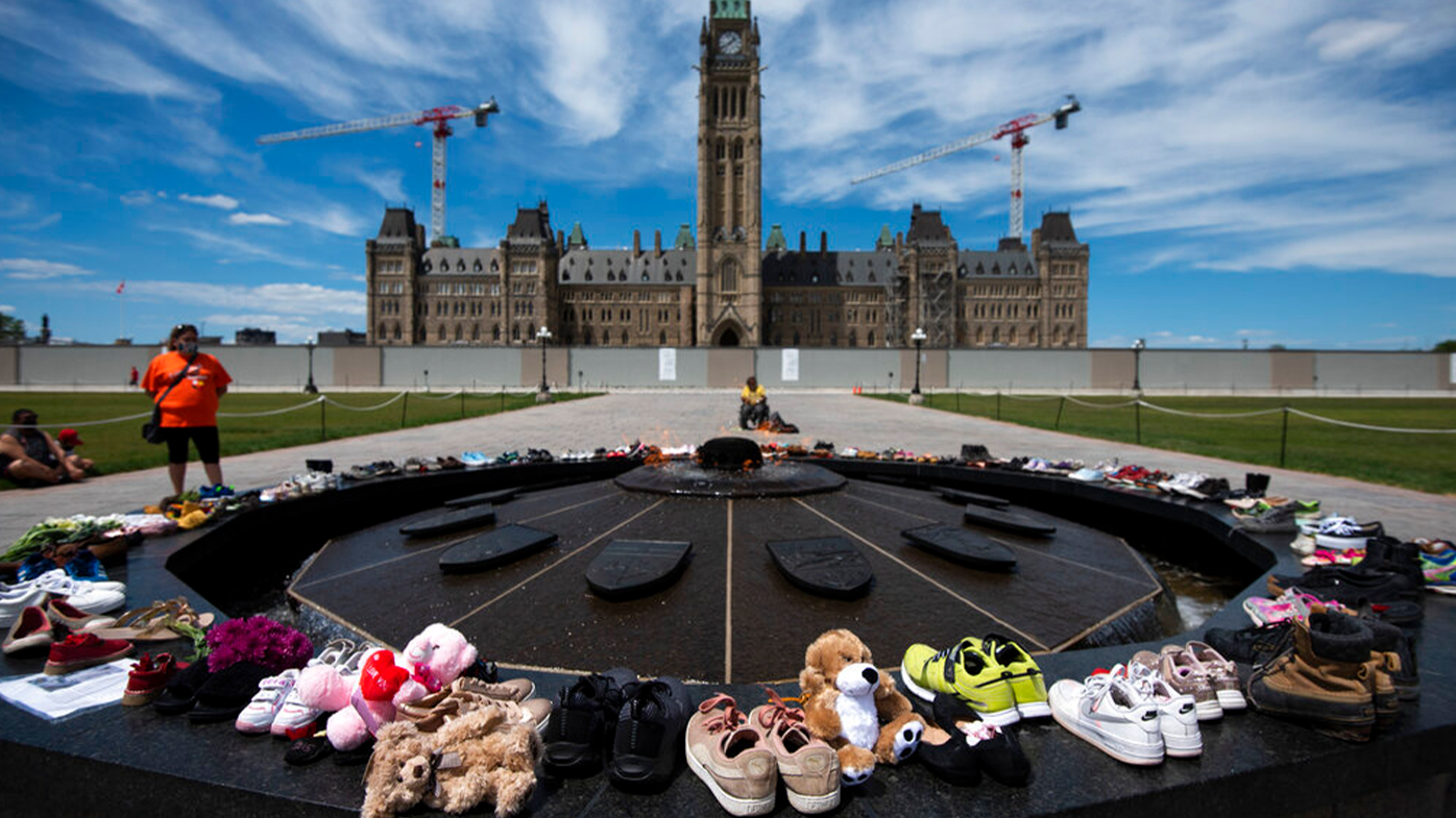 Shoes line the edge of the Centennial Flame on Parliament Hill in memory of the 215 children whose remains were found at the grounds of the former Kamloops Indian Residential School.