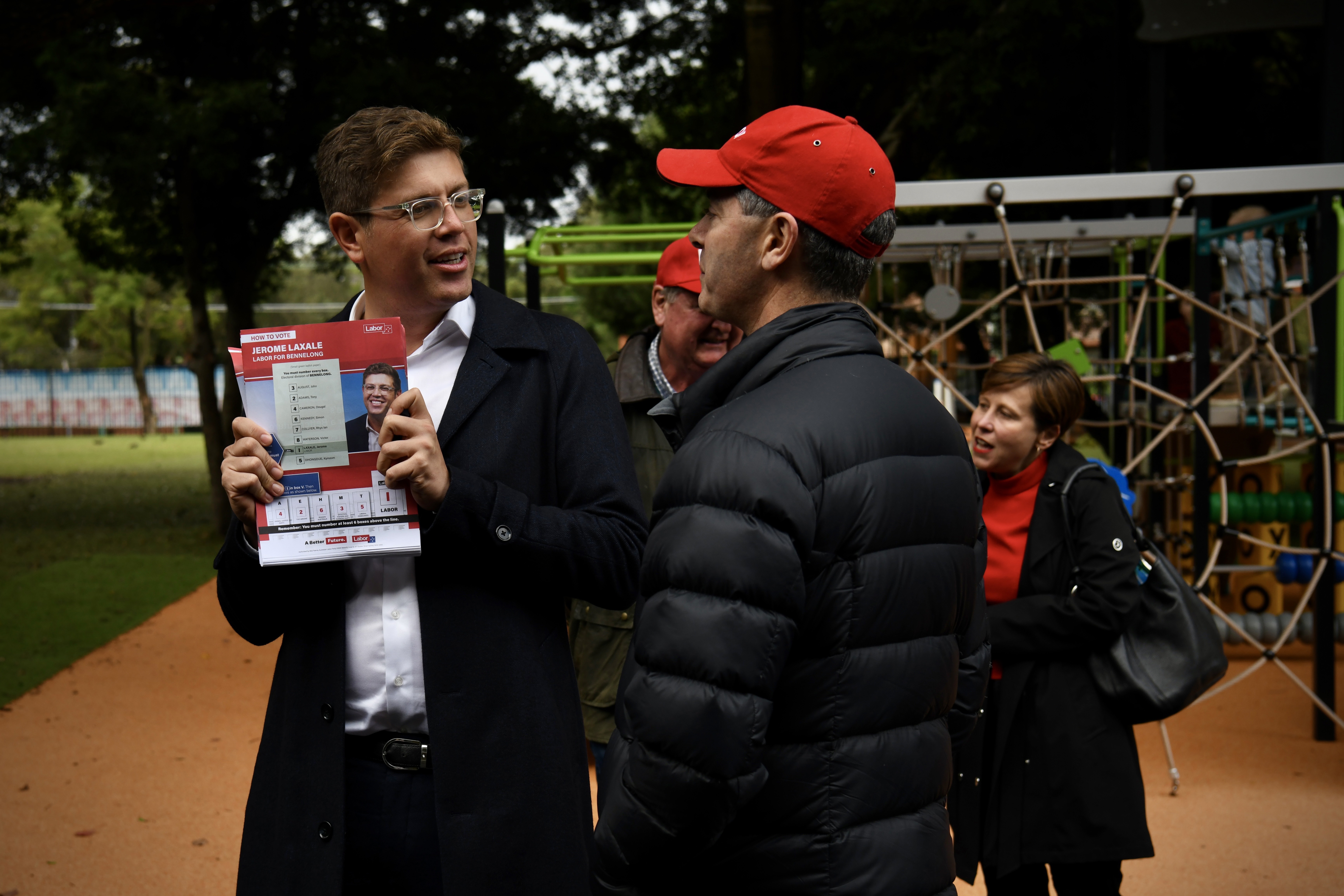 Jerome Laxale hands out how to vote forms to waiting crowds at West Ryde Public School, Sydney, Saturday 21 May, 2022.