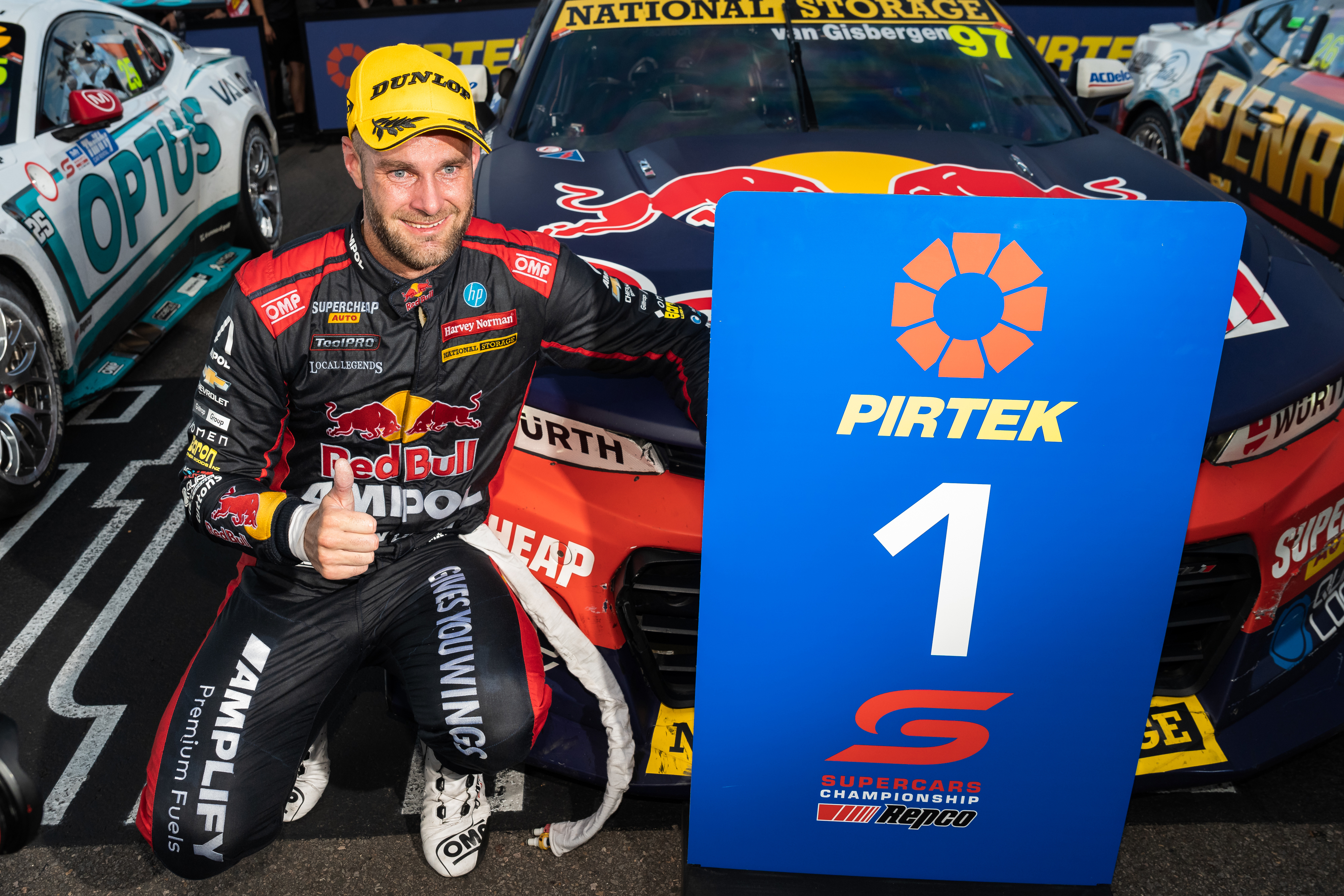 Shane van Gisbergen kneels next to his new Chevrolet Camaro after winning race two. 