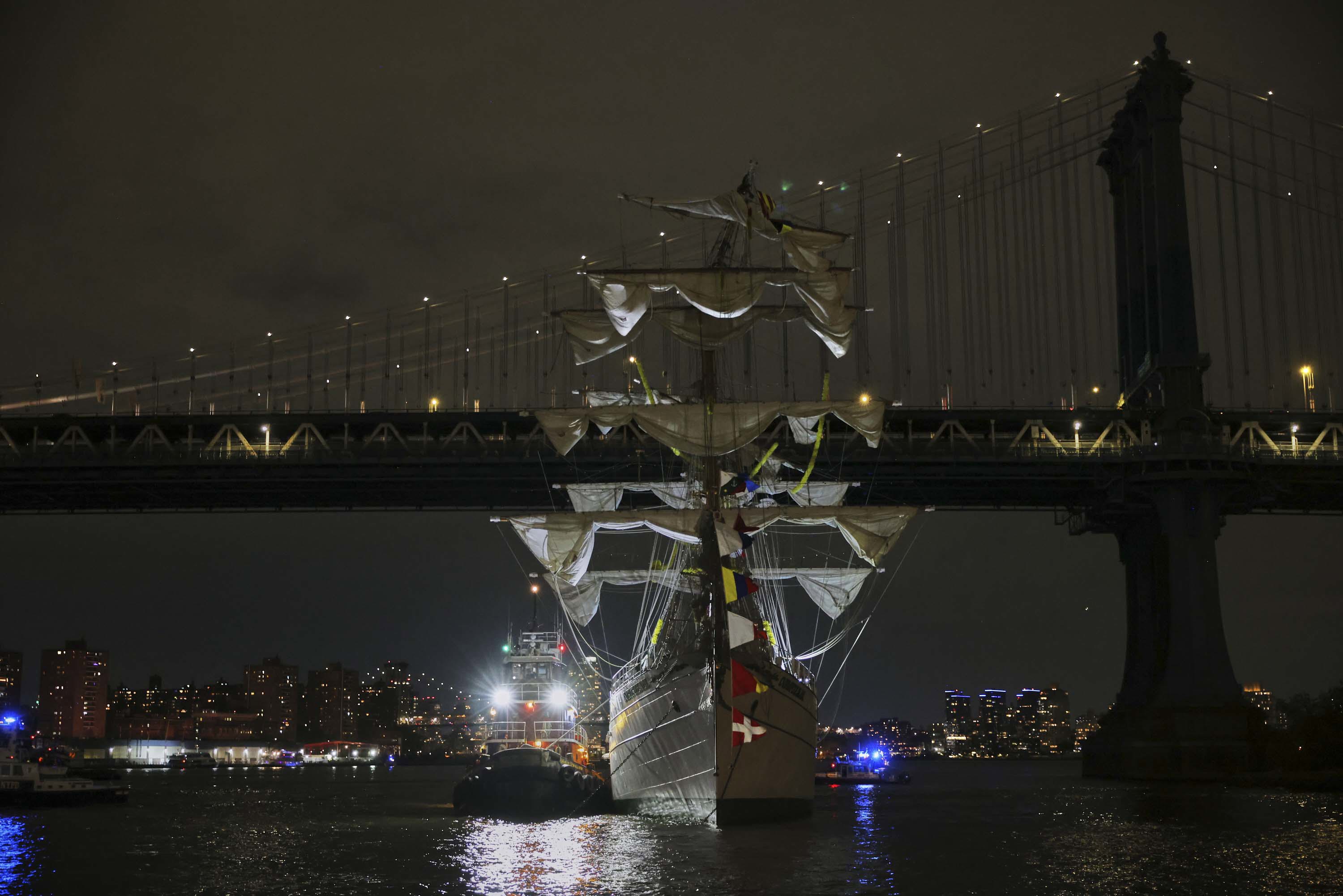 A tug boat helps stabilize the Cuauhtémoc, a masted Mexican Navy training ship as it sits stranded near the Manhattan Bridge after colliding with the Brooklyn Bridge.