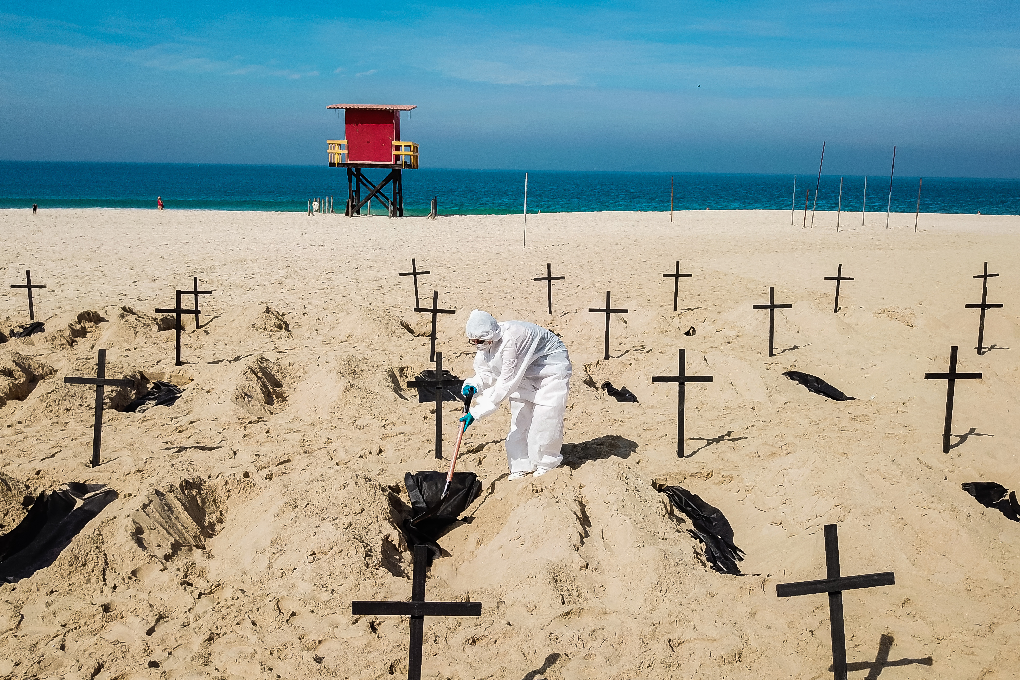 Protesters from the NGO 'Rio De Paz' dig symbolic graves as a sign of protest in Copacabana beach in Rio de Janeiro, Brazil. Volunteers dug 100 shallow graves symbolising the deaths of coronavirus in the country. The act calls for transparency and an attitude change from the government to fight the pandemic. 