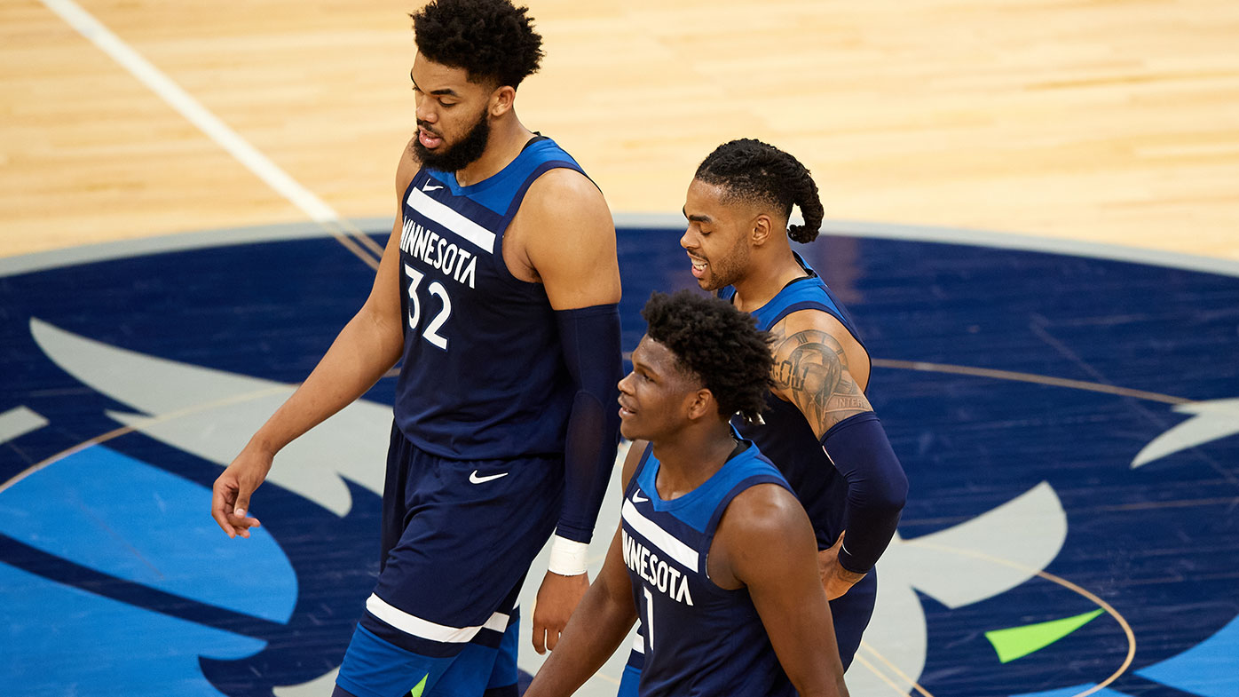 (L-R) Karl-Anthony Towns #32, Anthony Edwards #1 and D'Angelo Russell #0 of the Minnesota Timberwolves walk back to the bench 