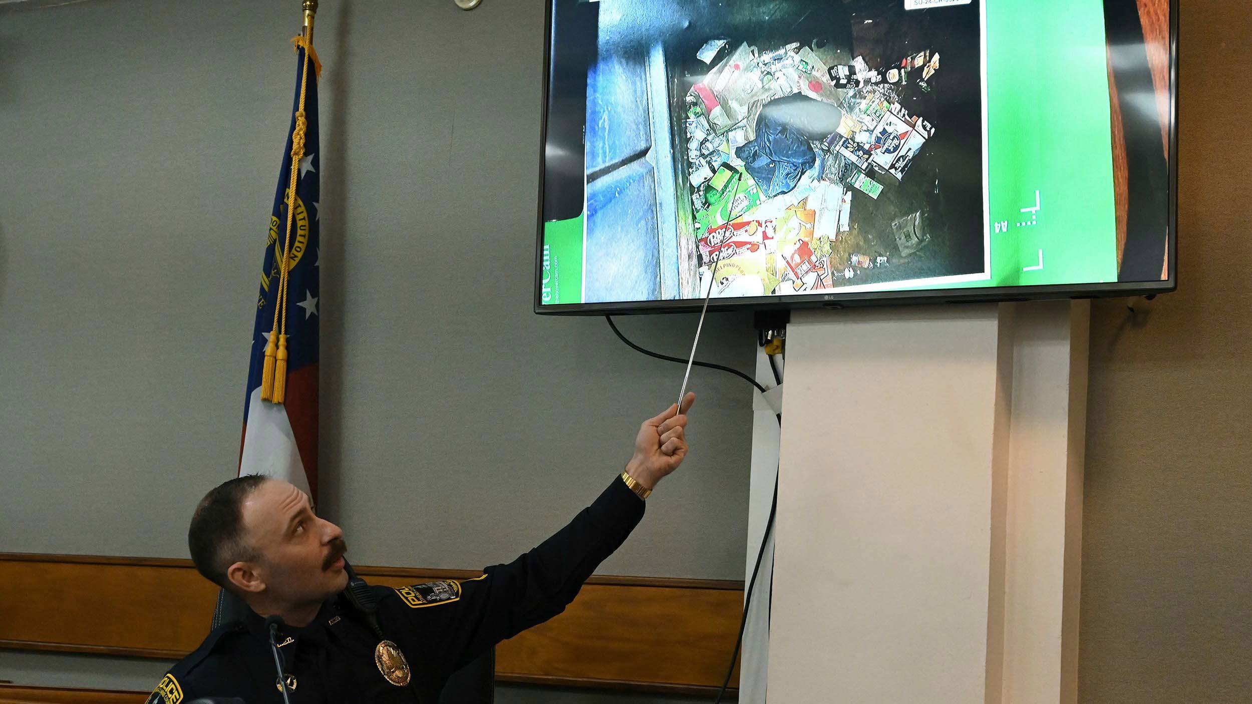 El oficial de policía del condado de Atenas-Clarke, Zachary Davis, señala la chaqueta que recogió de un contenedor de basura mientras testifica durante el juicio de José Ibarra el 15 de noviembre. Crédito obligatorio: Hyosub Shin/Pool/Atlanta Journal-Constitution/AP vía CNN Newsource