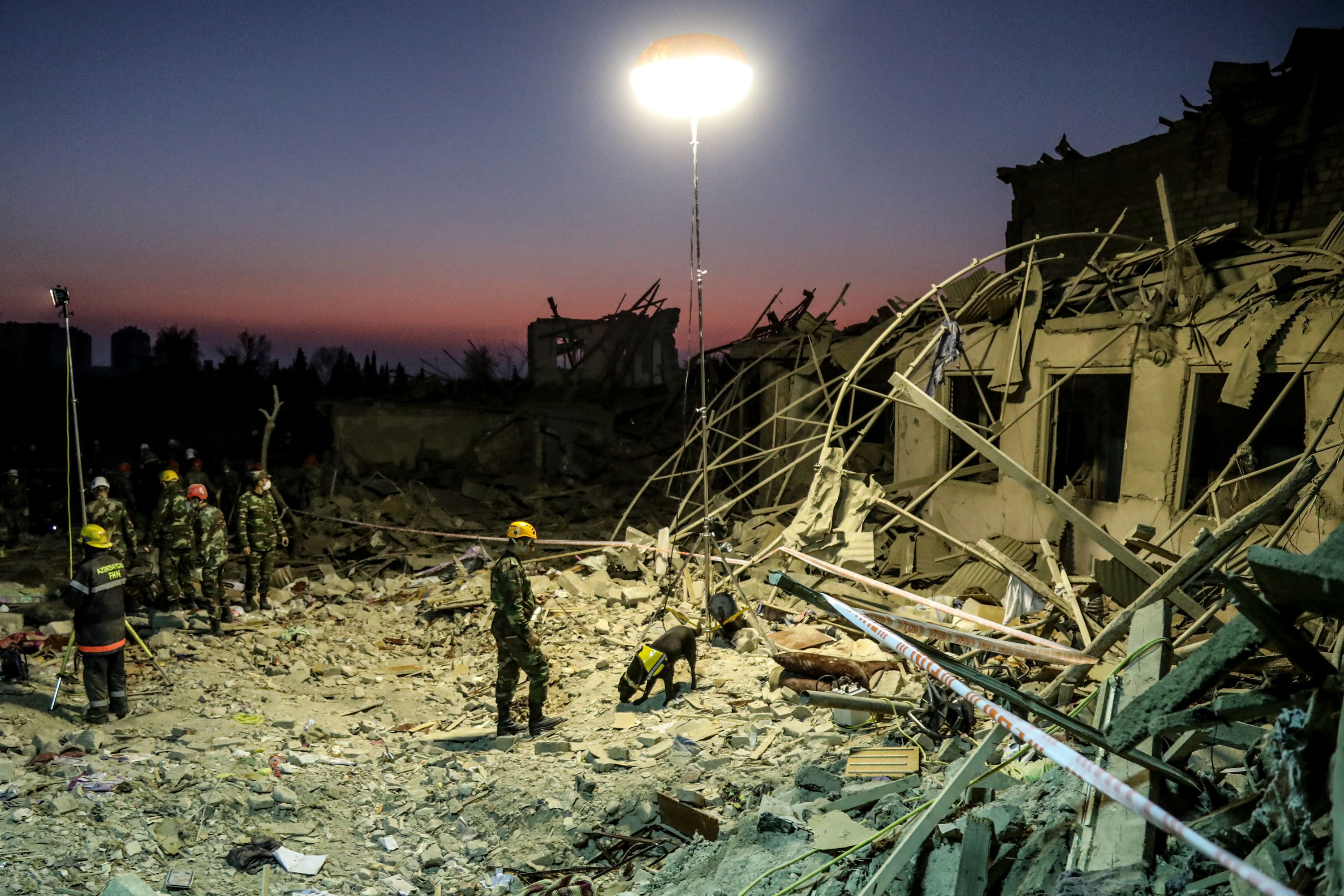 Search and rescue teams in Ganja, Azerbaijan, work at the blast site hit by a rocket during the fighting over the breakaway region of Nagorno-Karabakh on October 17