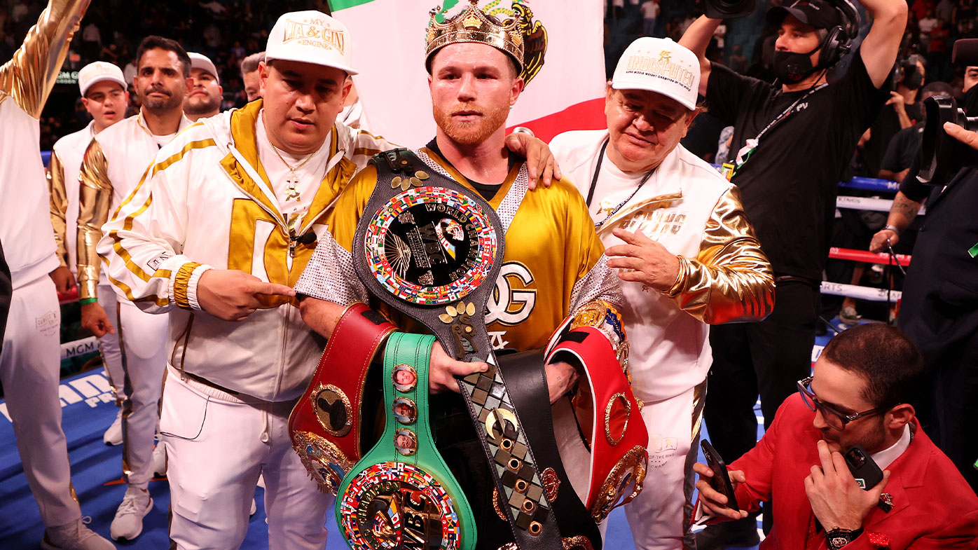 Canelo Alvarez poses with the belts after his championship bout for Alvarez's WBC, WBO and WBA super middleweight titles and Plant's IBF super middleweight title