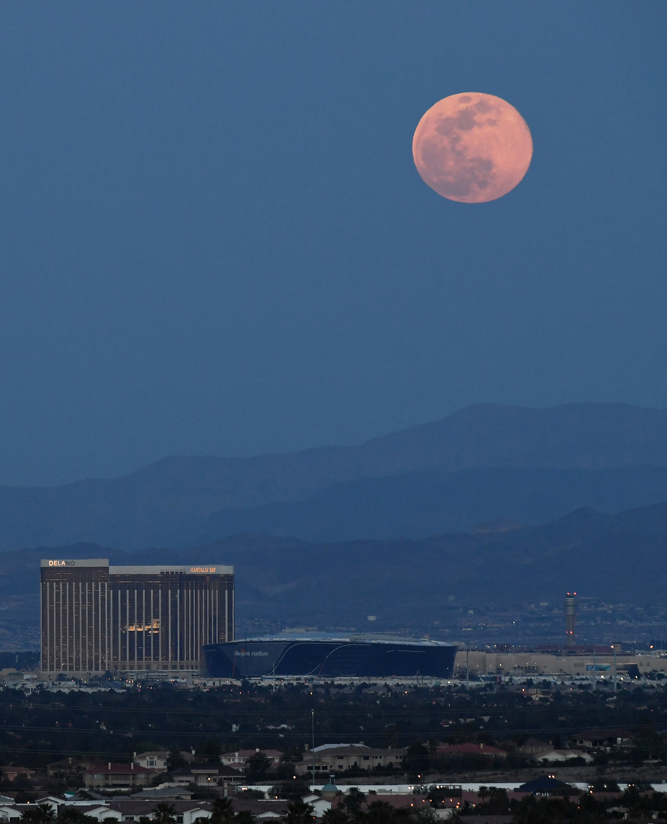 LAS VEGAS, NEVADA - APRIL 07:  The super pink moon, the biggest supermoon of the year, rises over (L-R) Delano Las Vegas at Mandalay Bay Resort and Casino, Mandalay Bay Resort and Casino, the under construction Allegiant Stadium and McCarran International Airport on April 7, 2020 in Las Vegas, Nevada. The pink moon got its name because the April full moon occurs at the same time as the pink wildflower Phlox subulata blooms in North America. A supermoon occurs when a full moon coincides with its 