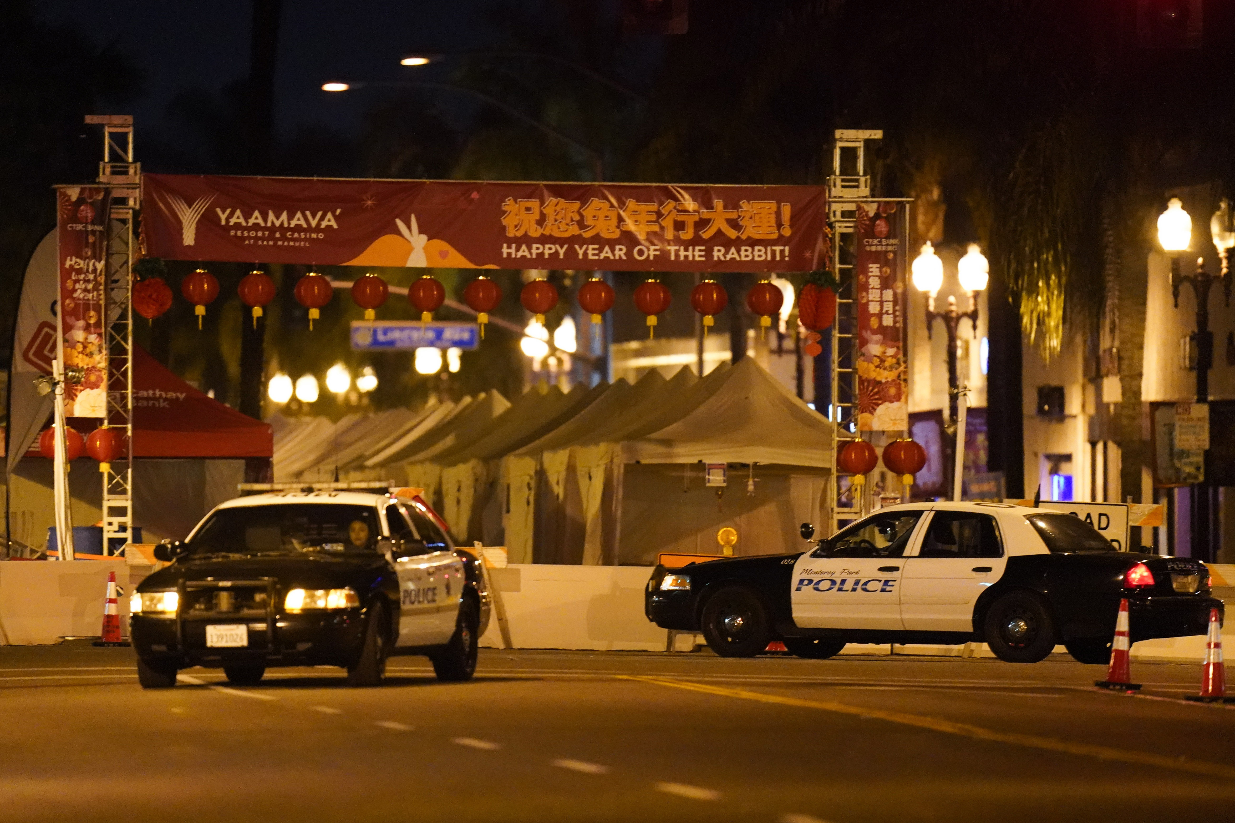 Two police vehicles are seen near a building where a shooting occurred in Monterey Park.