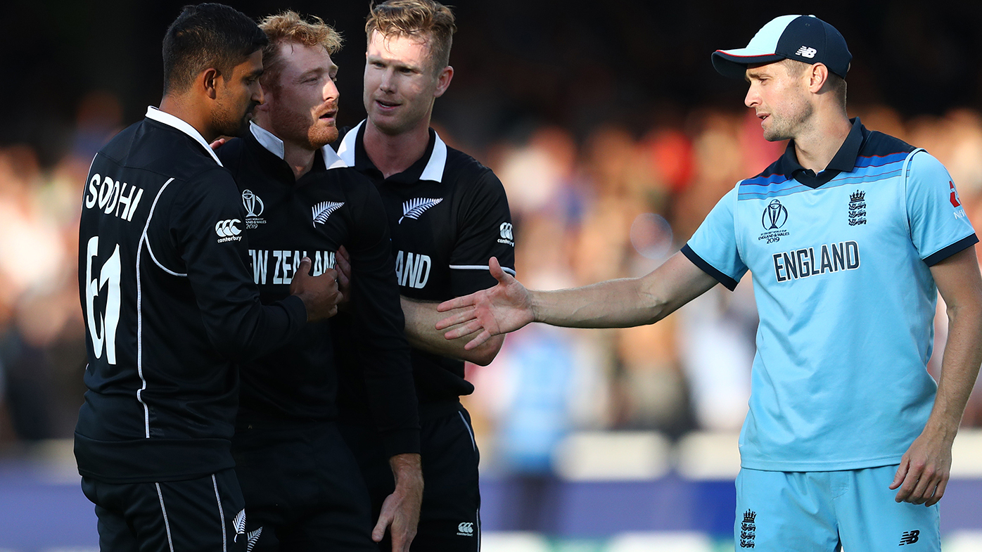 Chris Woakes of England offers his hand as to Martin Guptill as Jimmy Neesham and Ish Sodhi console the New Zealand batsman following the Super Over during the Final of the ICC Cricket World Cup 2019.