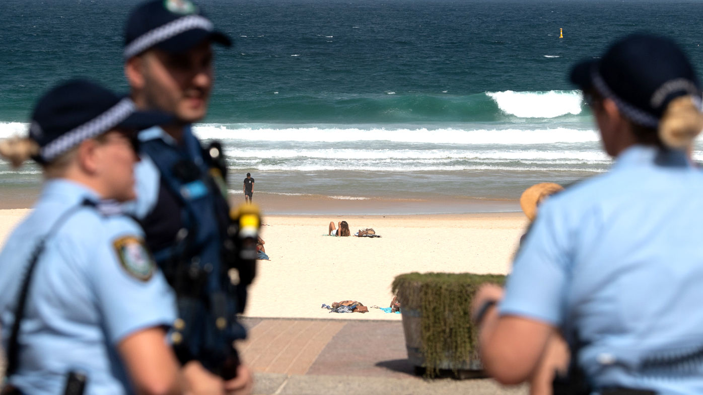 Police officers patrol Bondi Beach prior to its closure. Beachgoers drew condemnation yesterday when tens of thousands of people flouted social distancing rules, which have been put in place in an effort to limit the spread of COVID-19. Bondi Beach and other beaches have since been closed in Sydney's east.