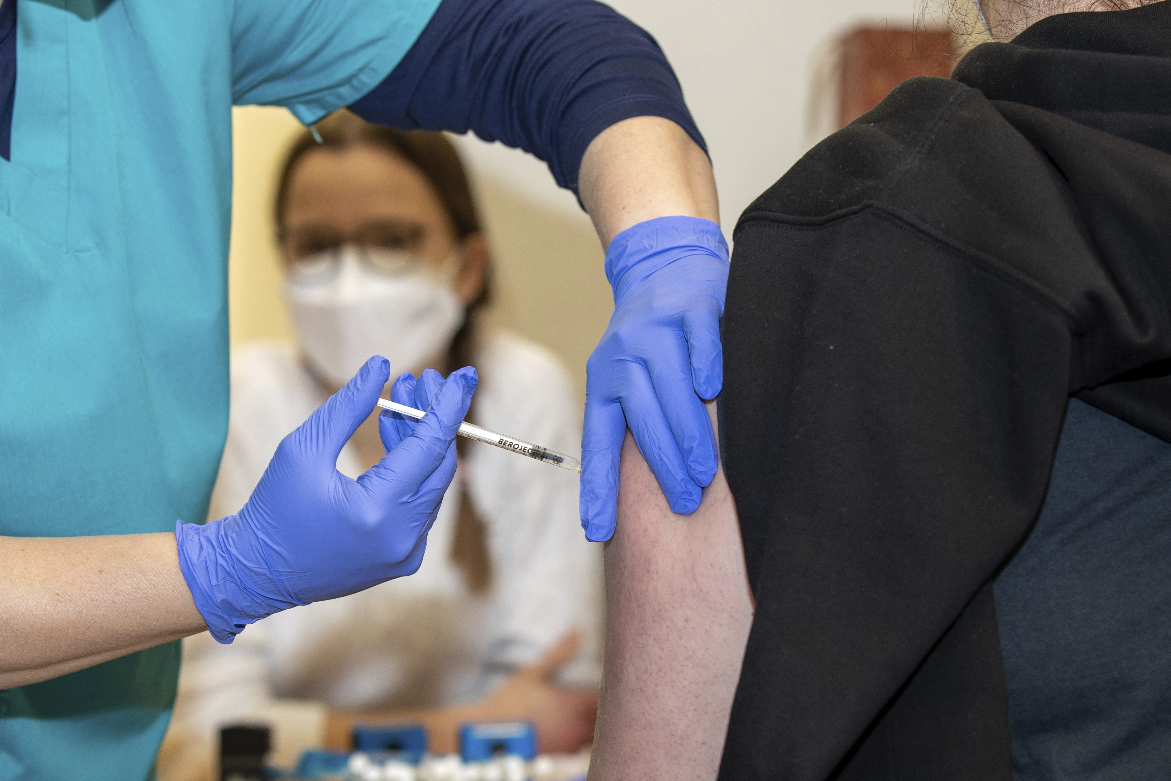 A doctor vaccinates a young woman with Moderna's mRNA vaccine at the Dresden State Art Collections in Dresden, Germany, Dec. 18, 2021. 