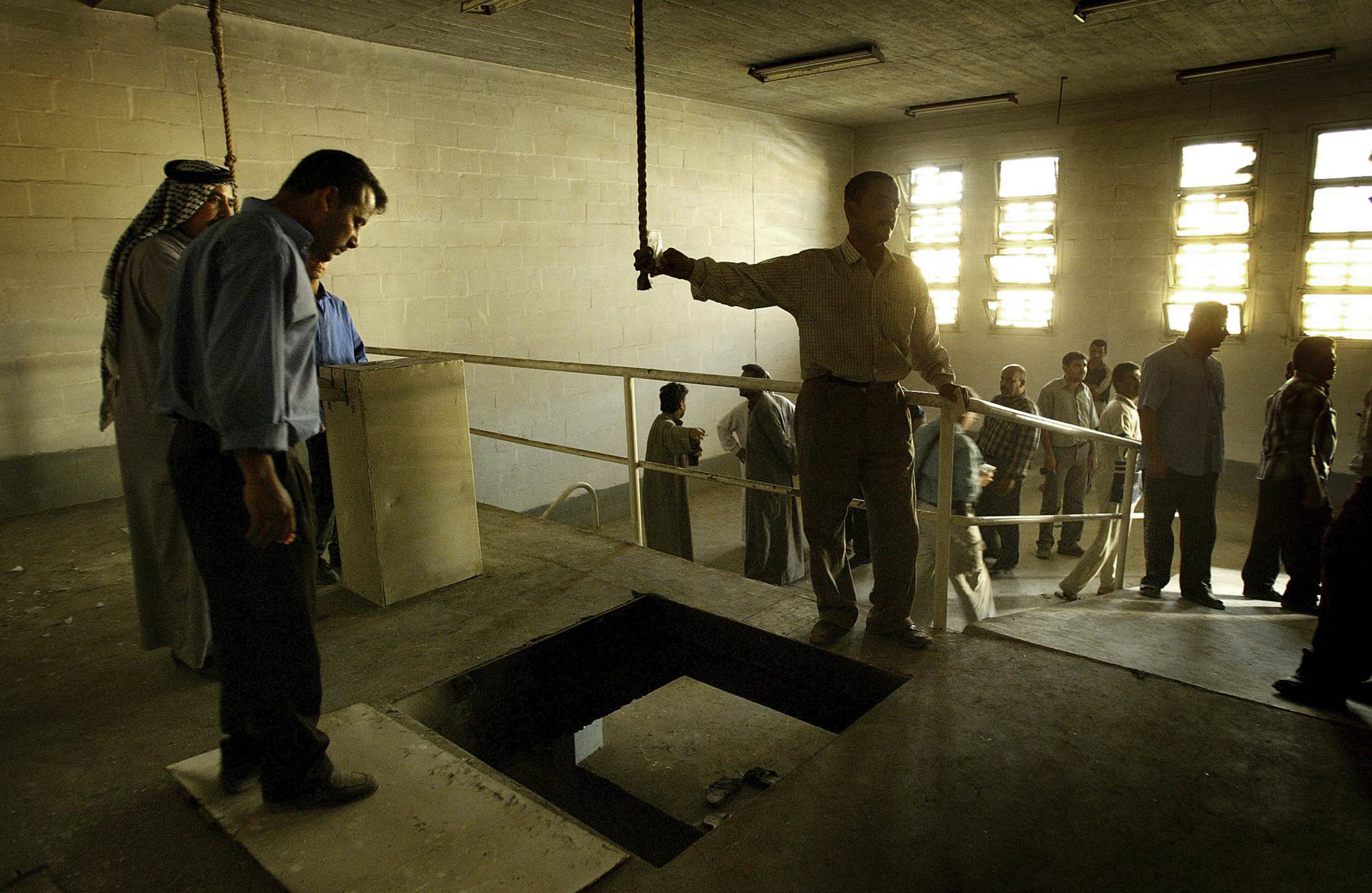  Iraqi men gather in the gallows at Abu Ghraib prison, Baghdad, Iraq. April 14, 2003. 