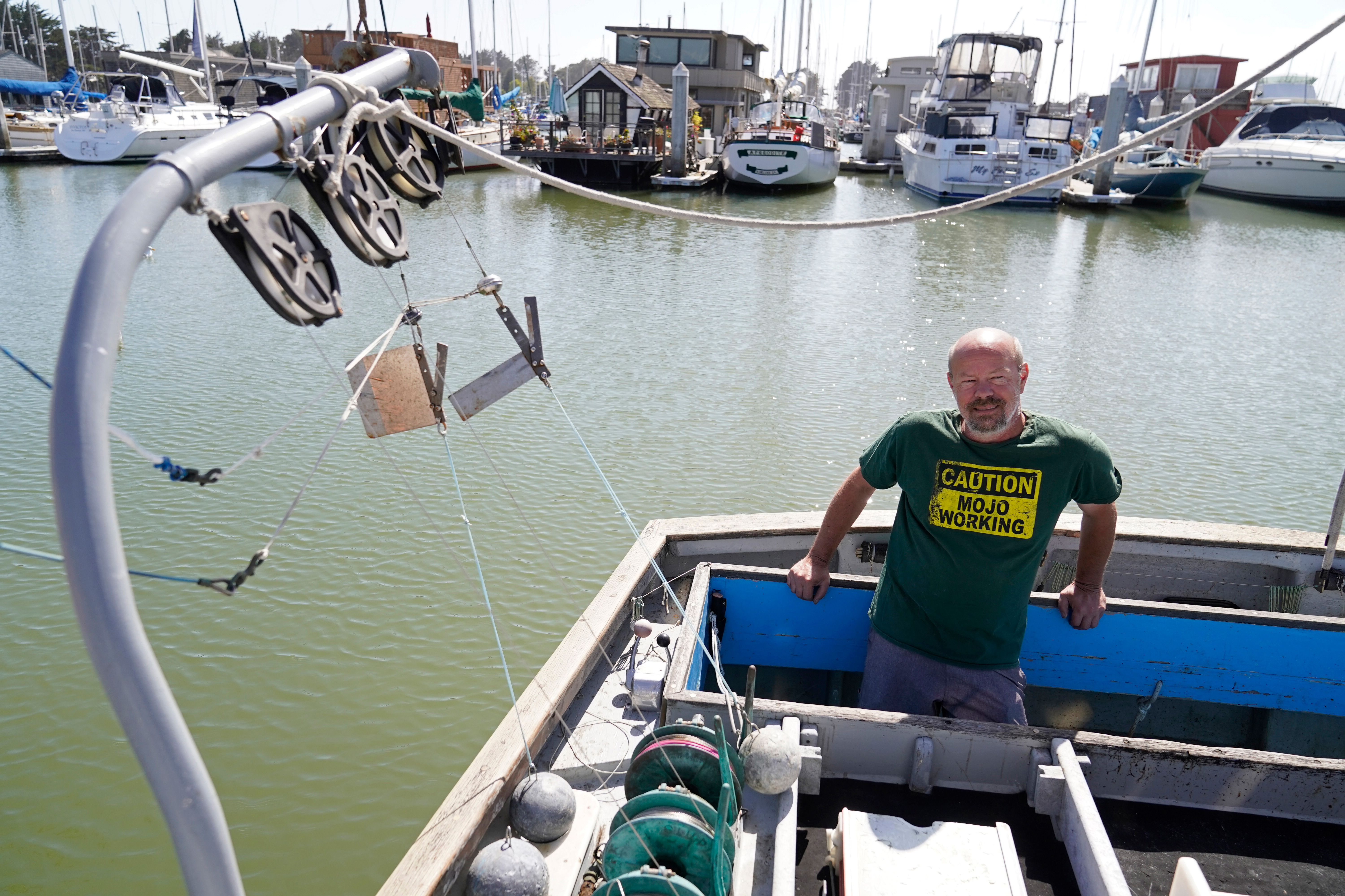 Salmon fisherman Mike Hudson stands at the back of his boat at the Berkeley Marina in California.