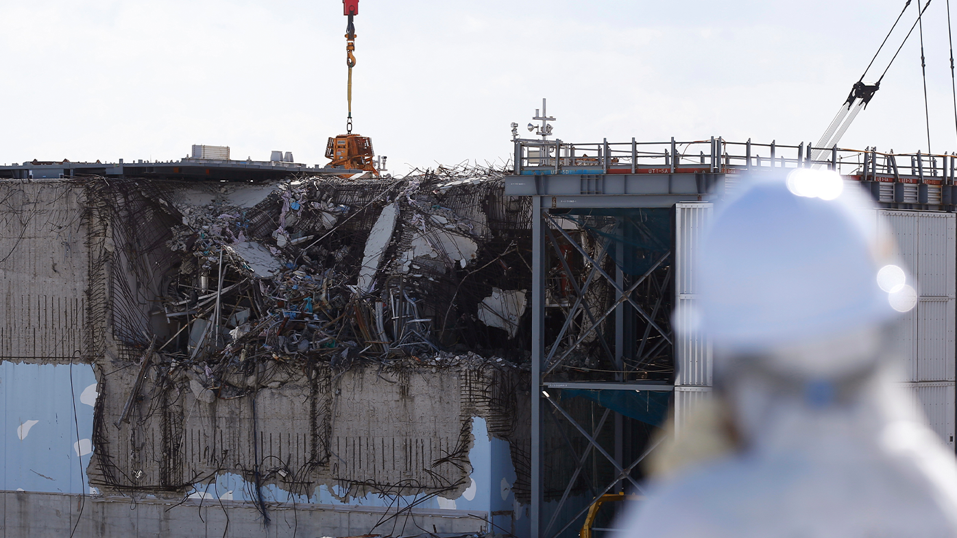 A member of the media, wearing a protective suit and a mask, looks at the No. 3 reactor building at Tokyo Electric Power Co's (TEPCO) tsunami-crippled Fukushima Daiichi nuclear power plant in Okuma town, Fukushima prefecture February 10, 2016. REUTERS/Toru Hanai/Pool