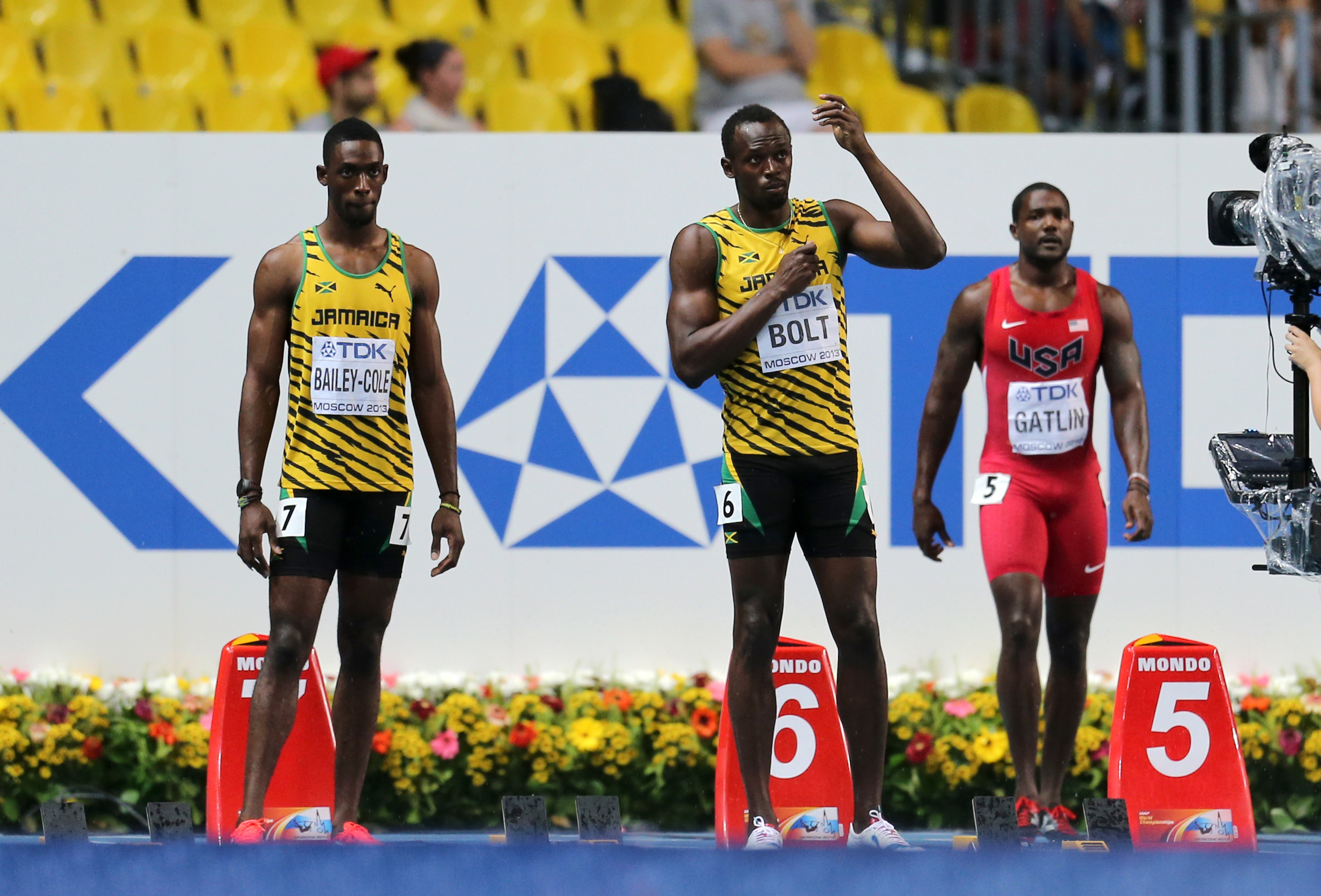 Usain Bolt mimes using an umbrella as rain tumbles ahead of the 100m final at the 2013 world athletics championships in Moscow.