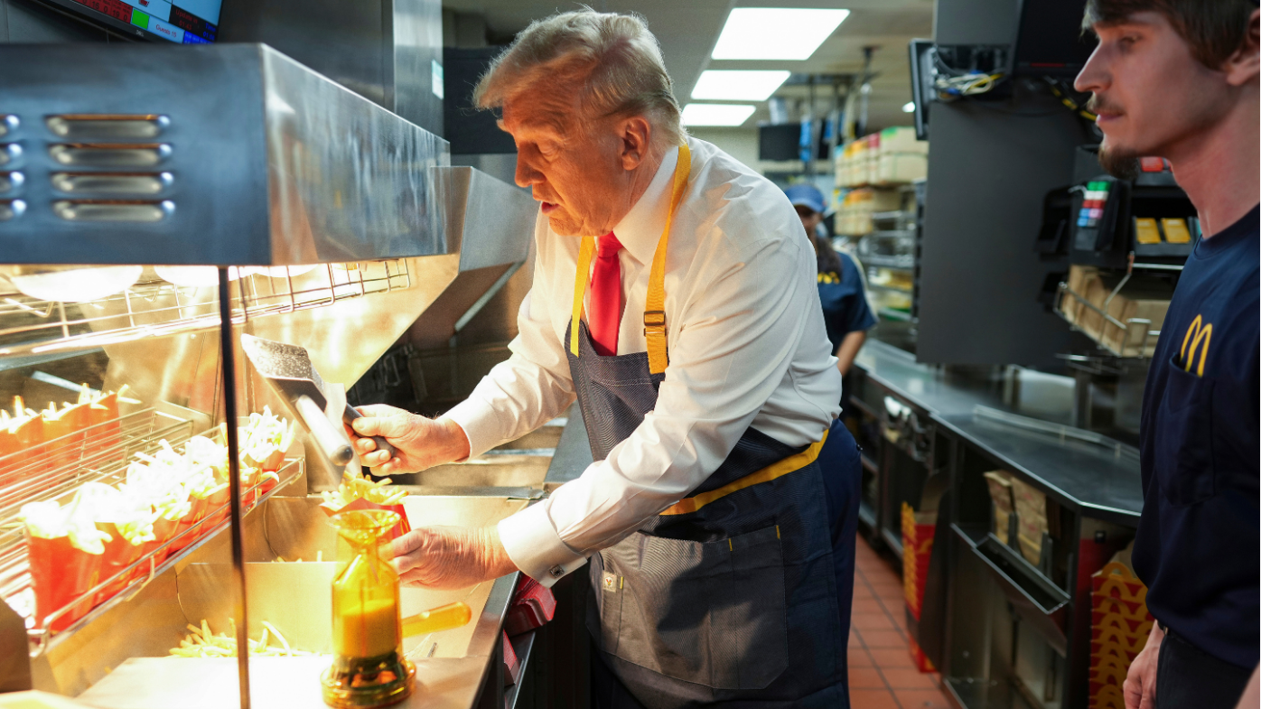 Donald Trump ayuda al personal de McDonald's a servir algunas papas fritas durante su visita de campaña a una tienda en el estado de Pensilvania, campo de batalla.