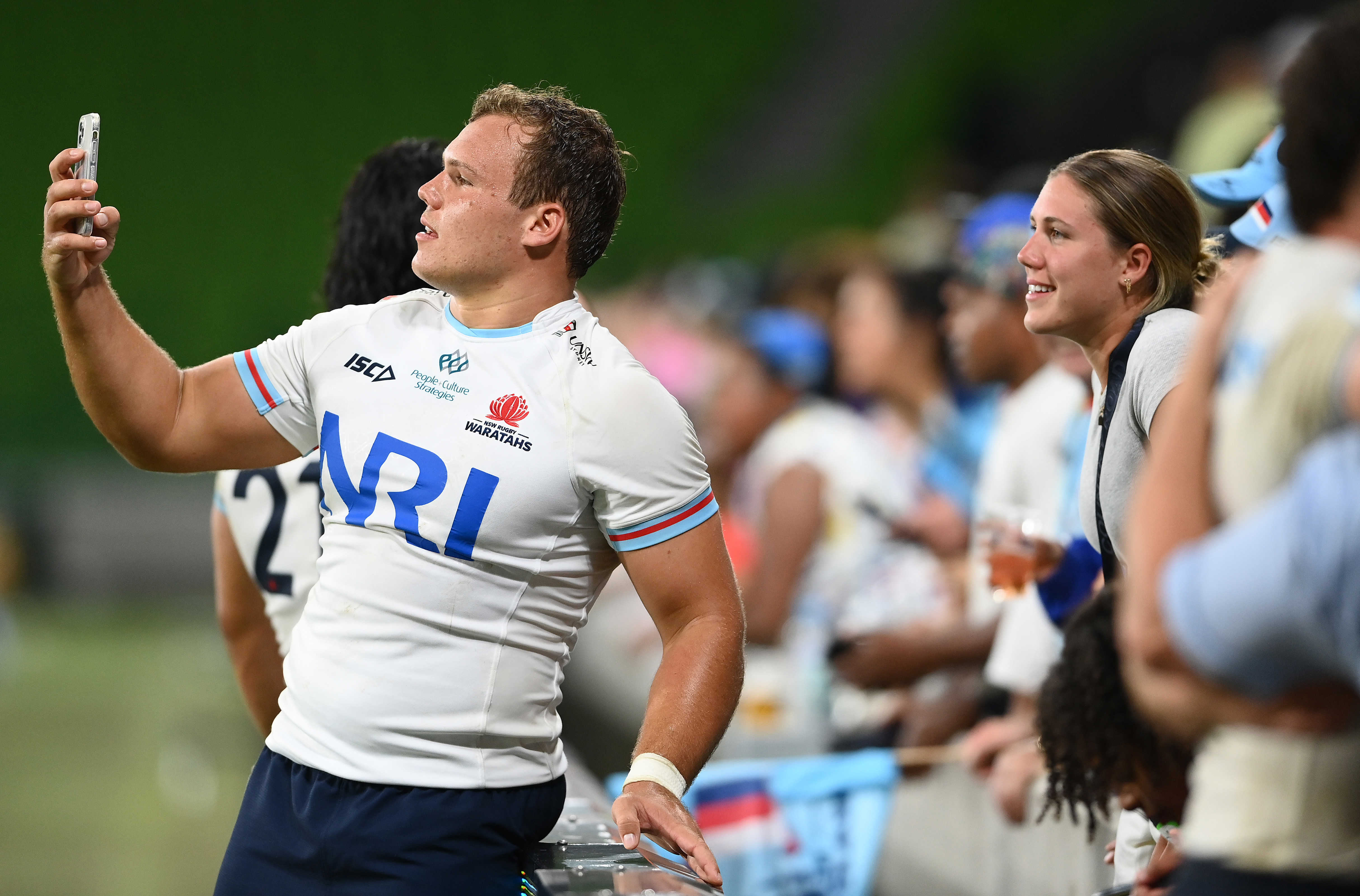 Daniel Botha of the NSW Waratahs takes photos with fans.