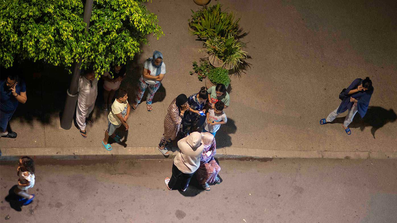 People take shelter and check for news on their mobile phones after an earthquake in Rabat, Morocco.