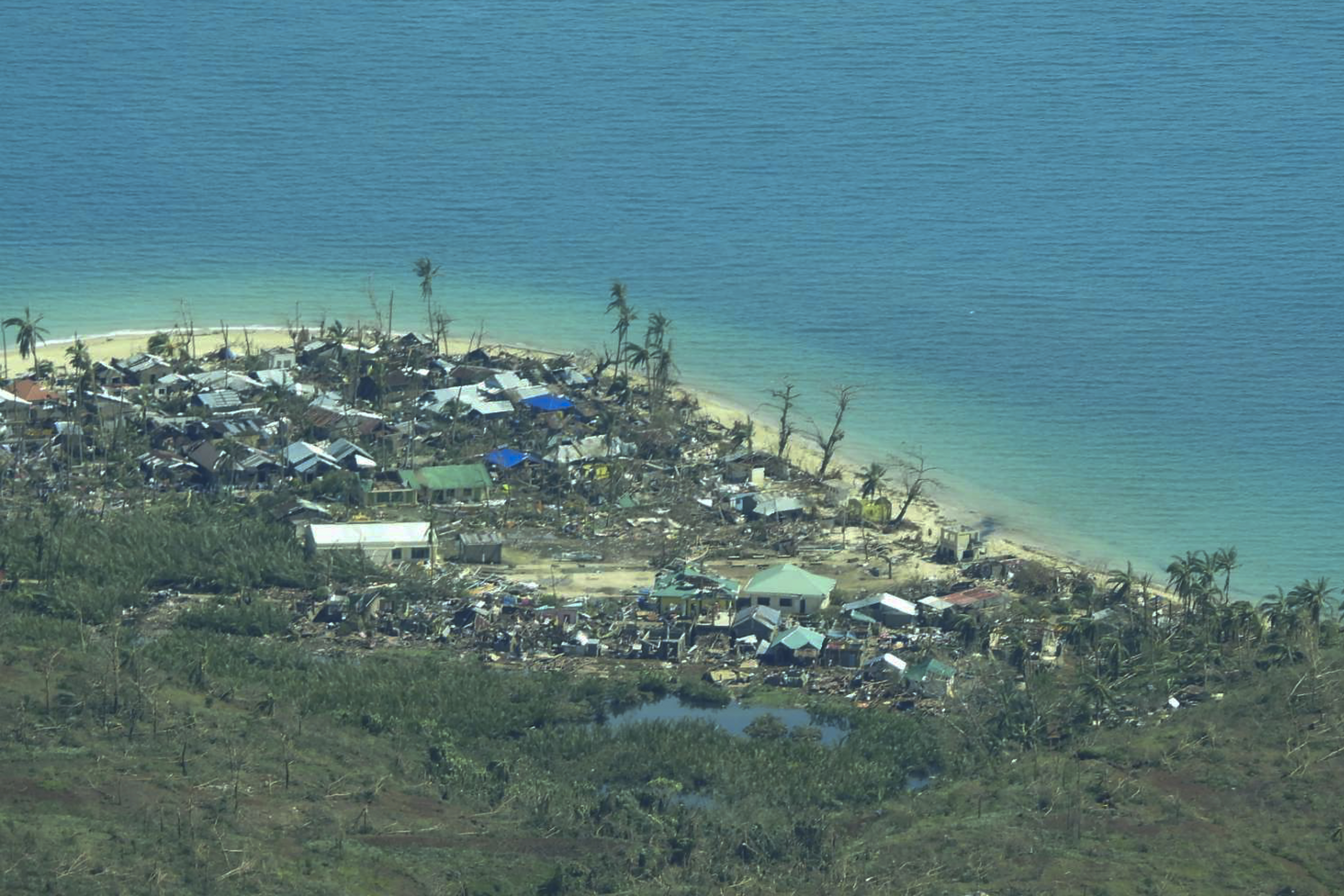 In this handout photo provided by the Philippine Coast Guard, damaged houses caused by Typhoon Rai at a coastal village in Surigao del Norte province, southern Philippines on Friday, Dec. 17, 2021. 
