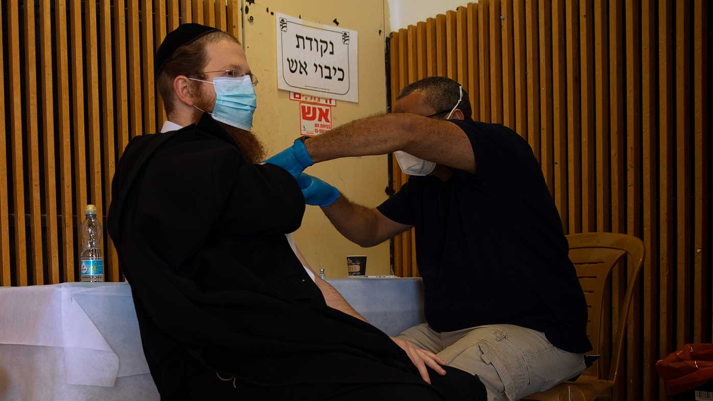 An ultra-Orthodox Jewish man receives a Pfizer-BioNTech coronavirus vaccine at a COVID-19 vaccination center in the West Bank Jewish settlement of Givat Zeev, near Jerusalem.