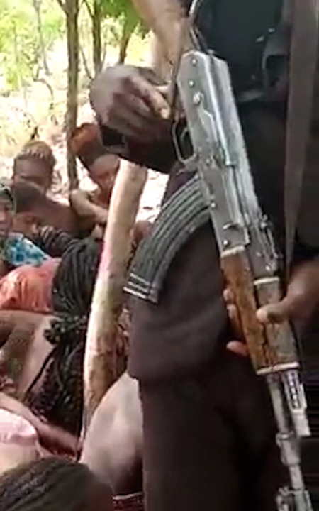 A gunman stands amongst the students, in a video which emerged over the weekend.