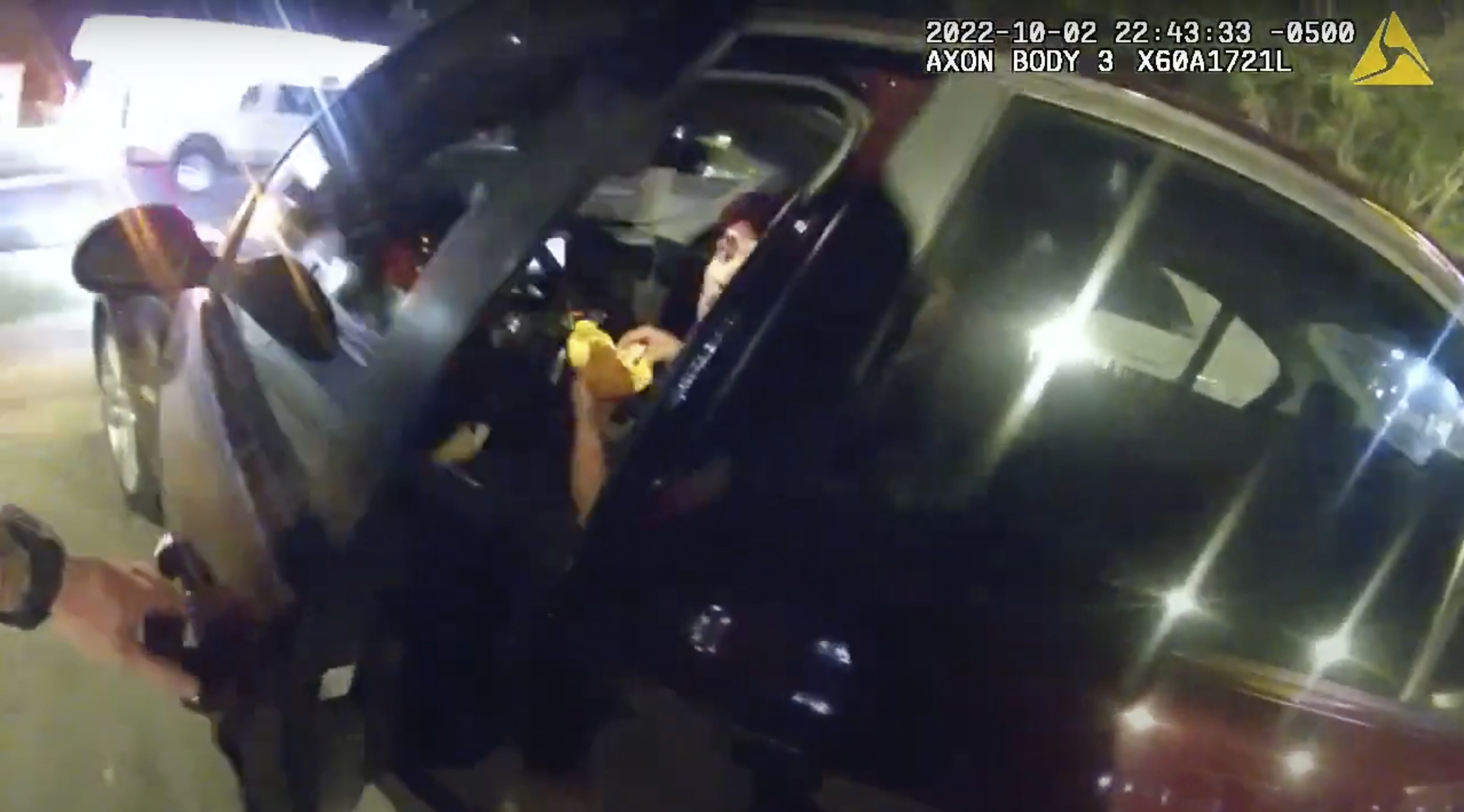 In this image taken from Oct. 2, 2022 police body camera video and released by San Antonio Police Department, Erik Cantu looks toward San Antonio Police officer James Brennand while holding a hamburger in a fast food restaurant parking lot as the officer opens the car door in San Antonio, Texas. Brennand opened fire several times wounding the unarmed teenager as he drove away. 