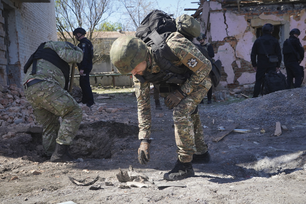 A police officer examines fragments of a guided bomb after the Russian air raid in Kharkiv, Ukraine, Tuesday, April 30, 2024. 