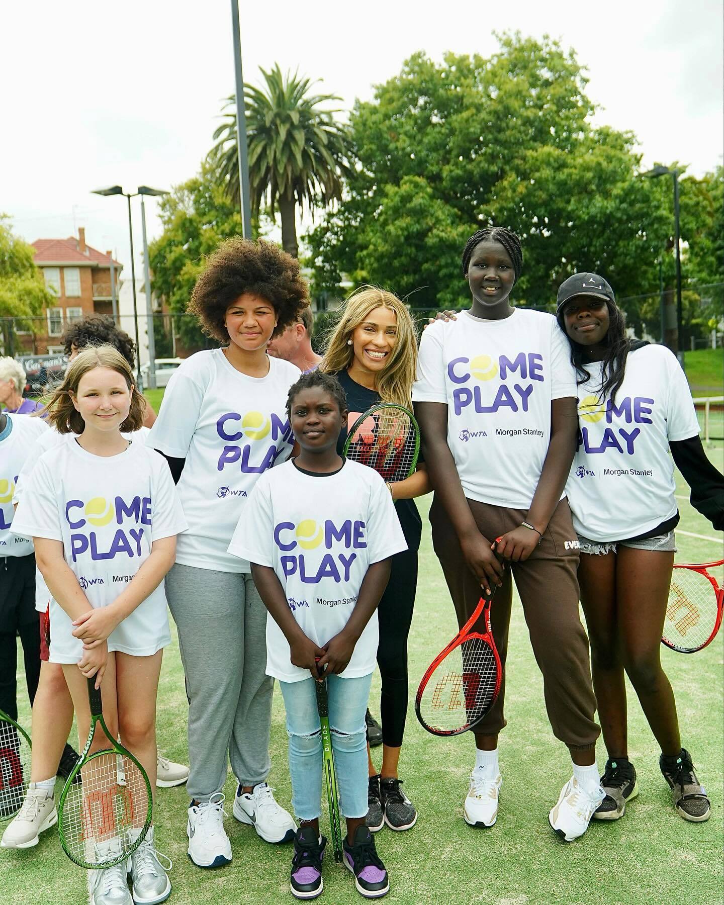 Ayan Broomfield with young tennis players in Australia during an event encouraging kids in sport.