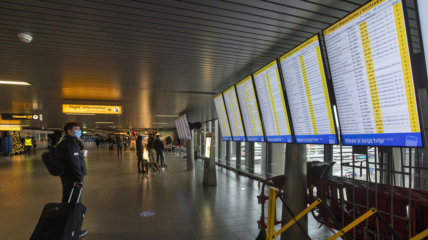 A traveller wearing a face mask checks the flight departures at Schiphol Airport, near Amsterdam, Netherlands (Photo: December 18, 2020)