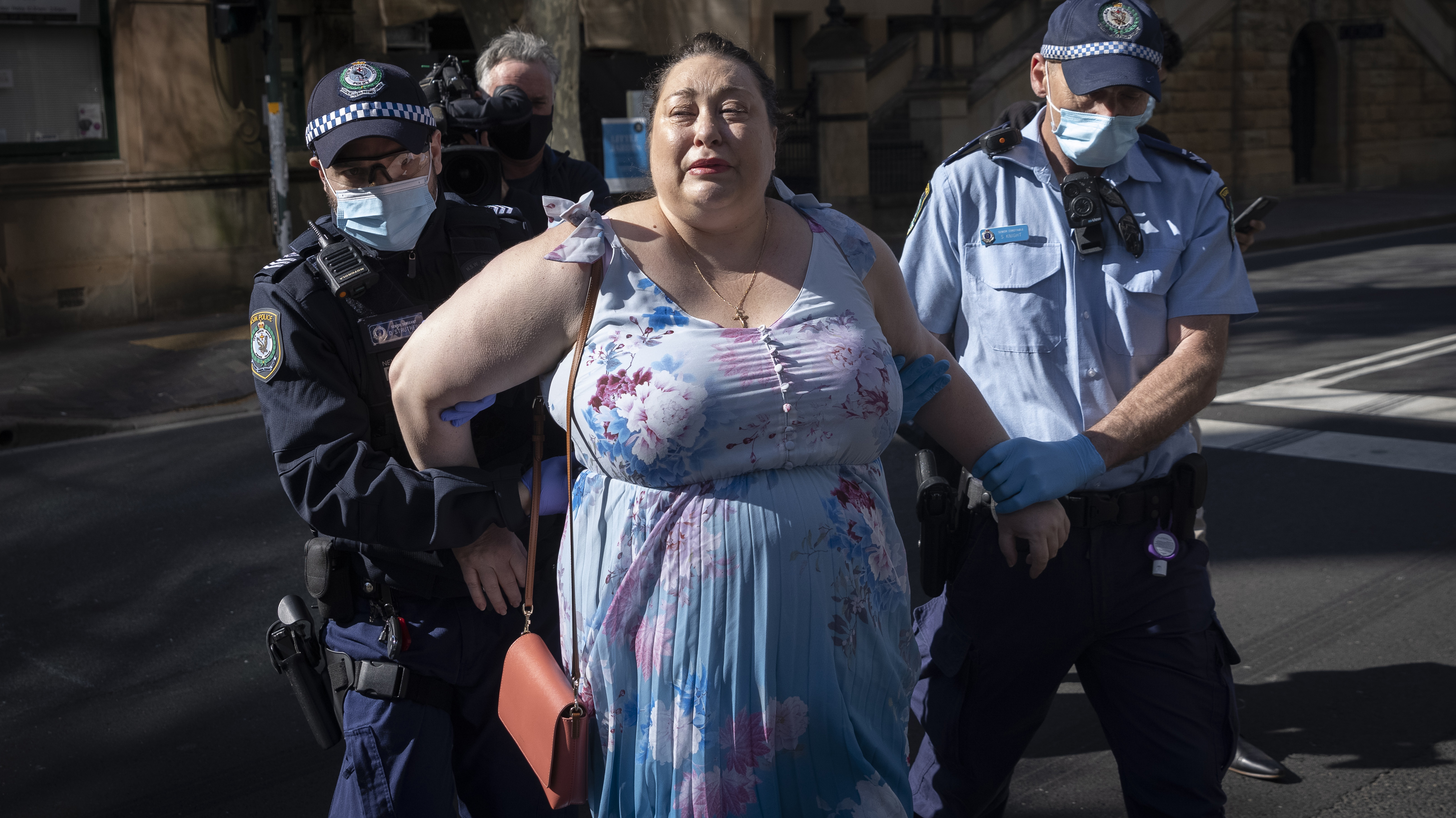 A woman is arrested outside the Parliament of New South Wales in Sydney.