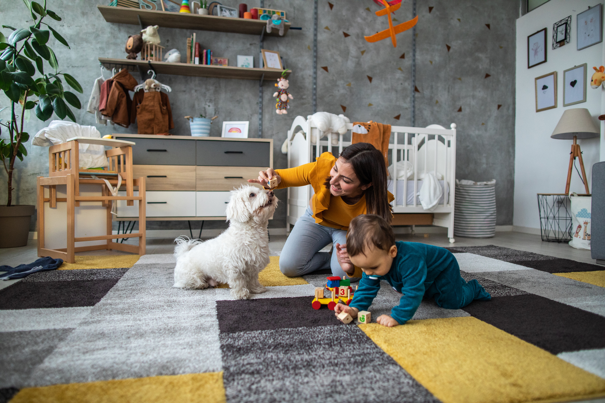Mum, baby and dog playing in baby nursery.